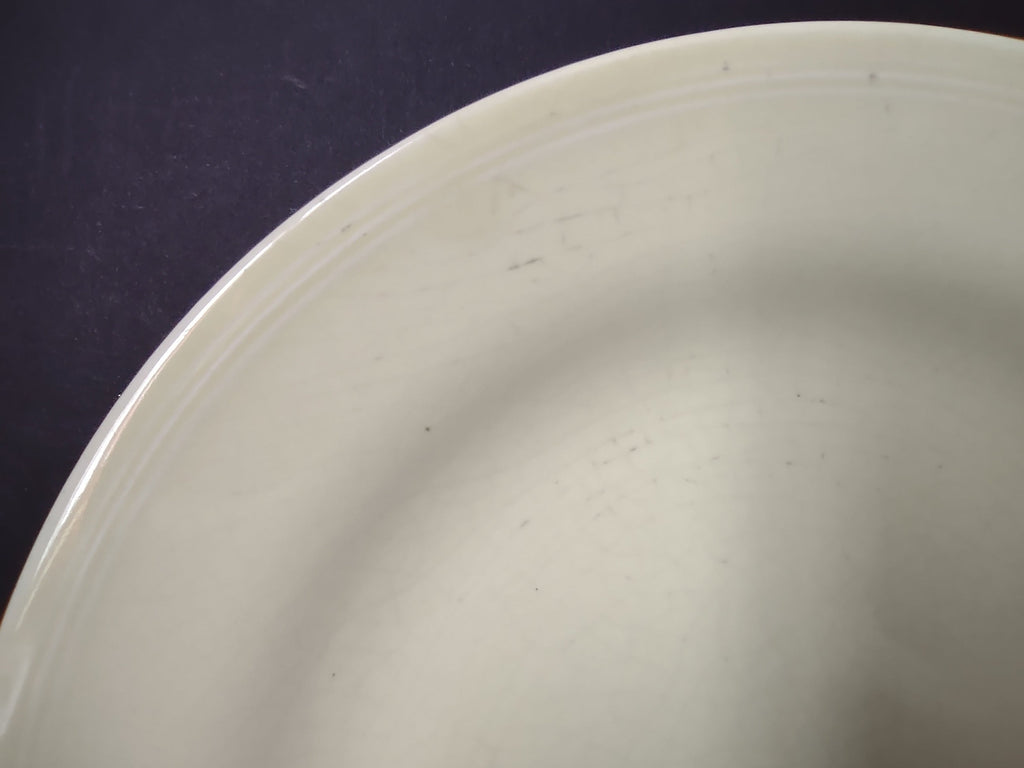 Vintage Unmarked Off-White Pale Yellow Glaze 9 inch Plate - close-up of surface showing light scratches
