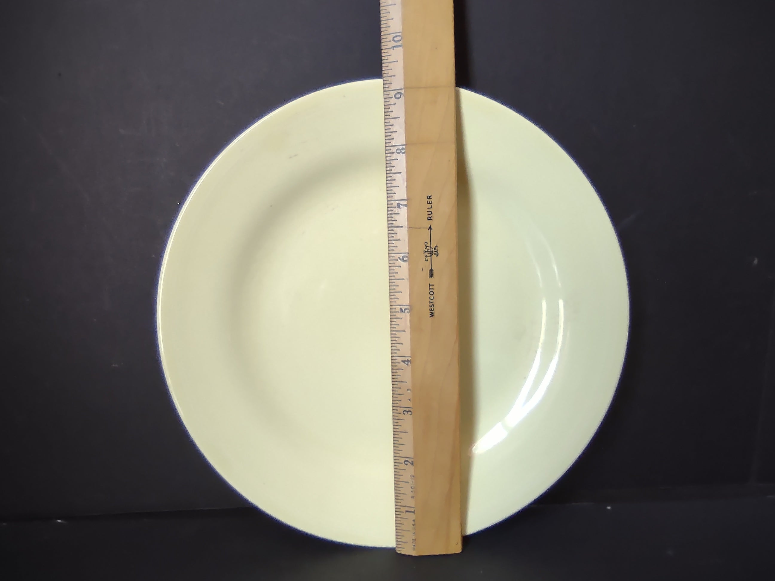 Vintage Unmarked Off-White Pale Yellow Glaze 9 inch Plate - ruler showing approximately 9 inch diameter