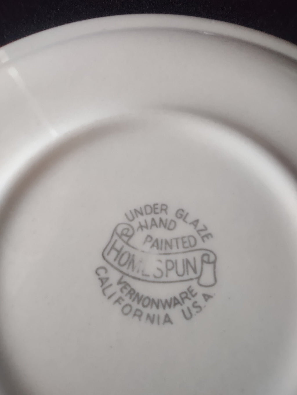 Vernon Kilns Homespun saucer top showing green, yellow and rust plaid pattern
