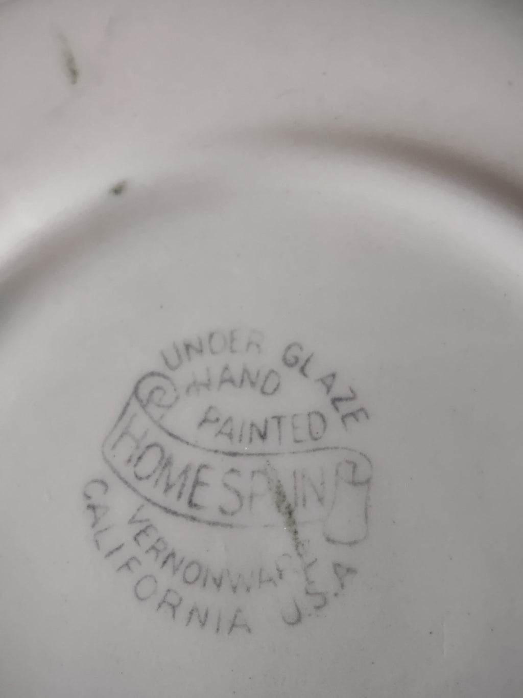 Full top-down view of Vernon Kilns Homespun saucer on display stand