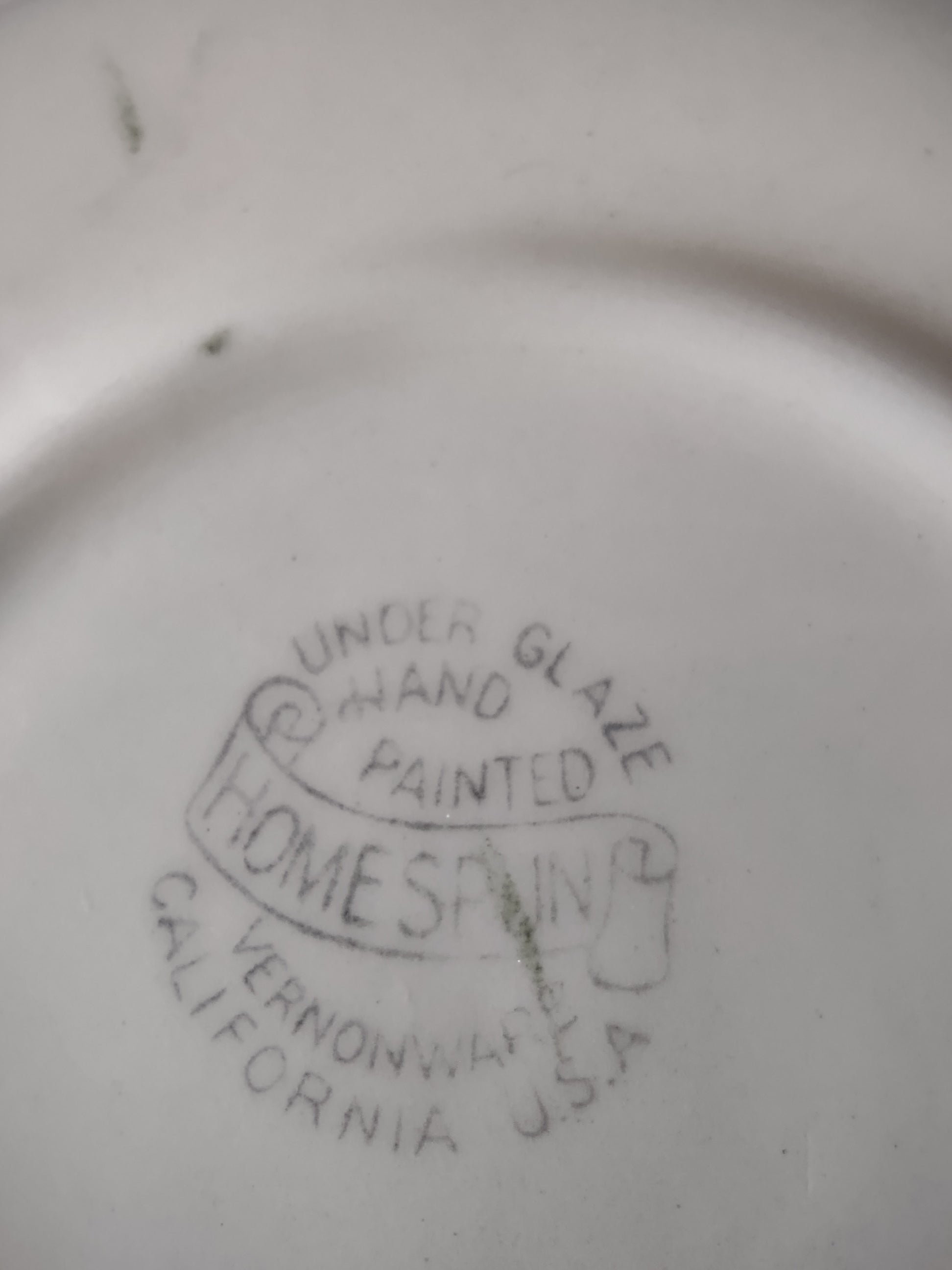 Full top-down view of Vernon Kilns Homespun saucer on display stand