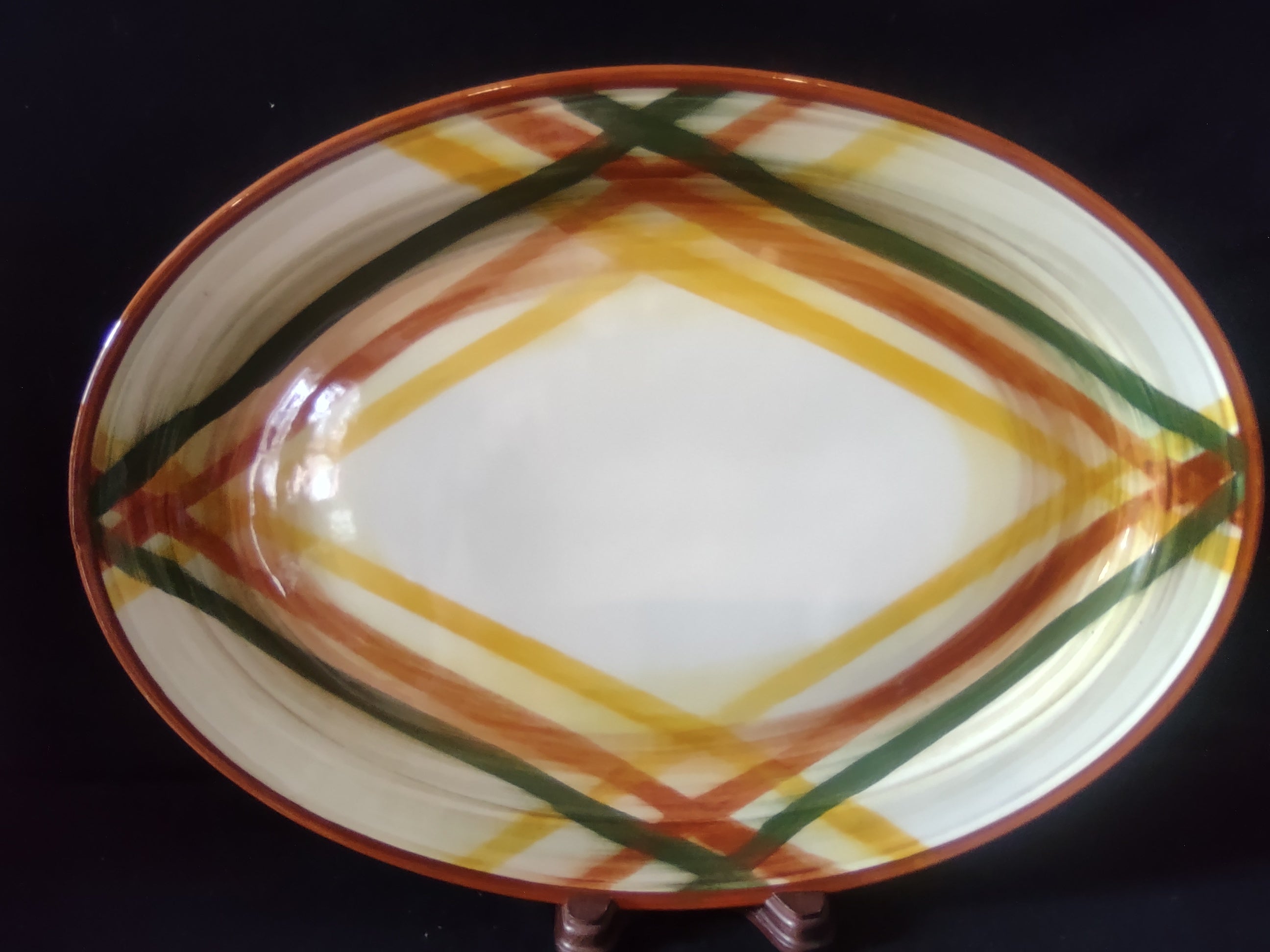 Vintage plaid oval serving platter with rust, yellow, and green stripe pattern - front view