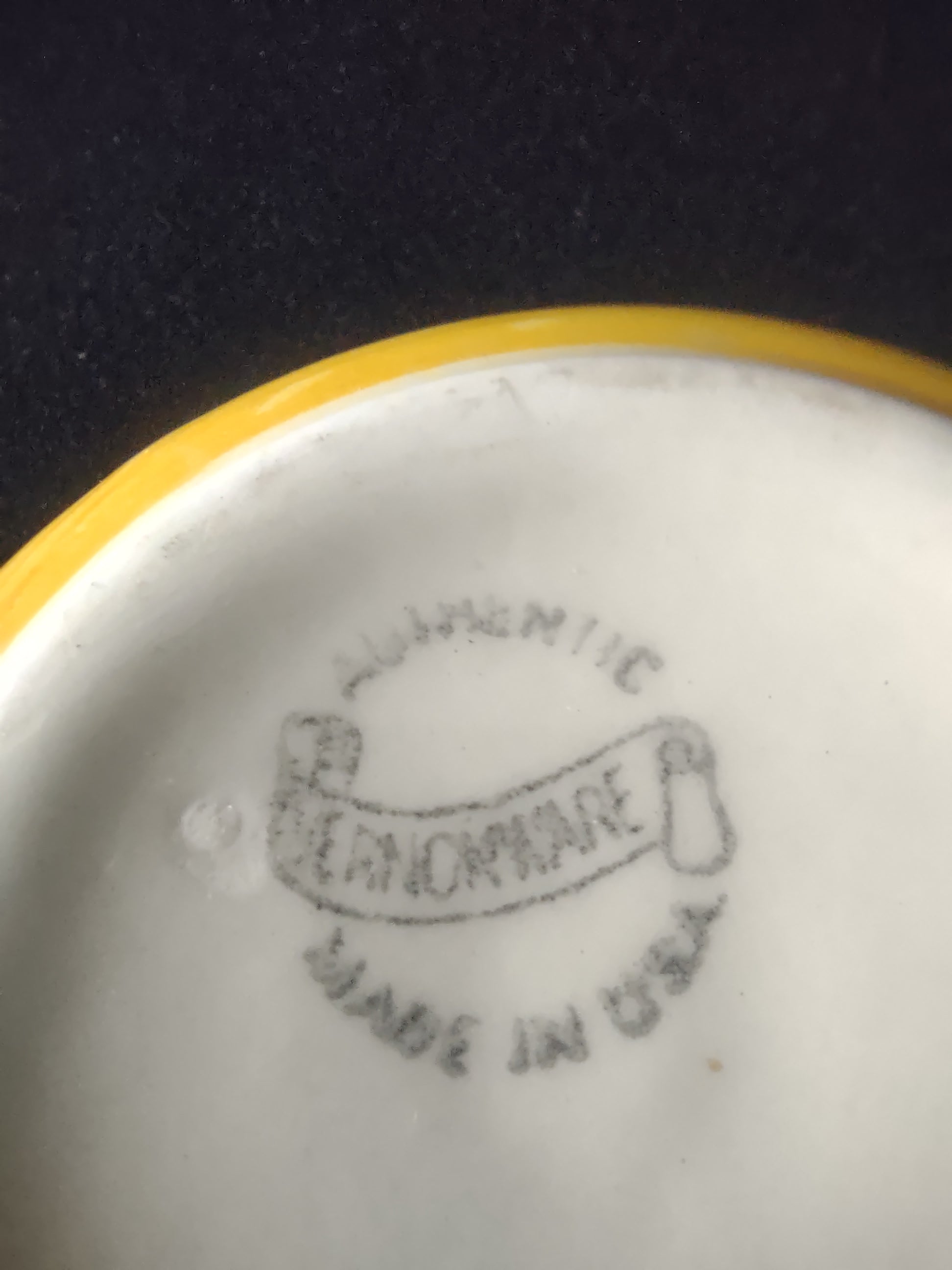 Vernonware Homespun handled soup bowl - bottom view showing yellow foot rim and backstamp, chip visible on handle tip