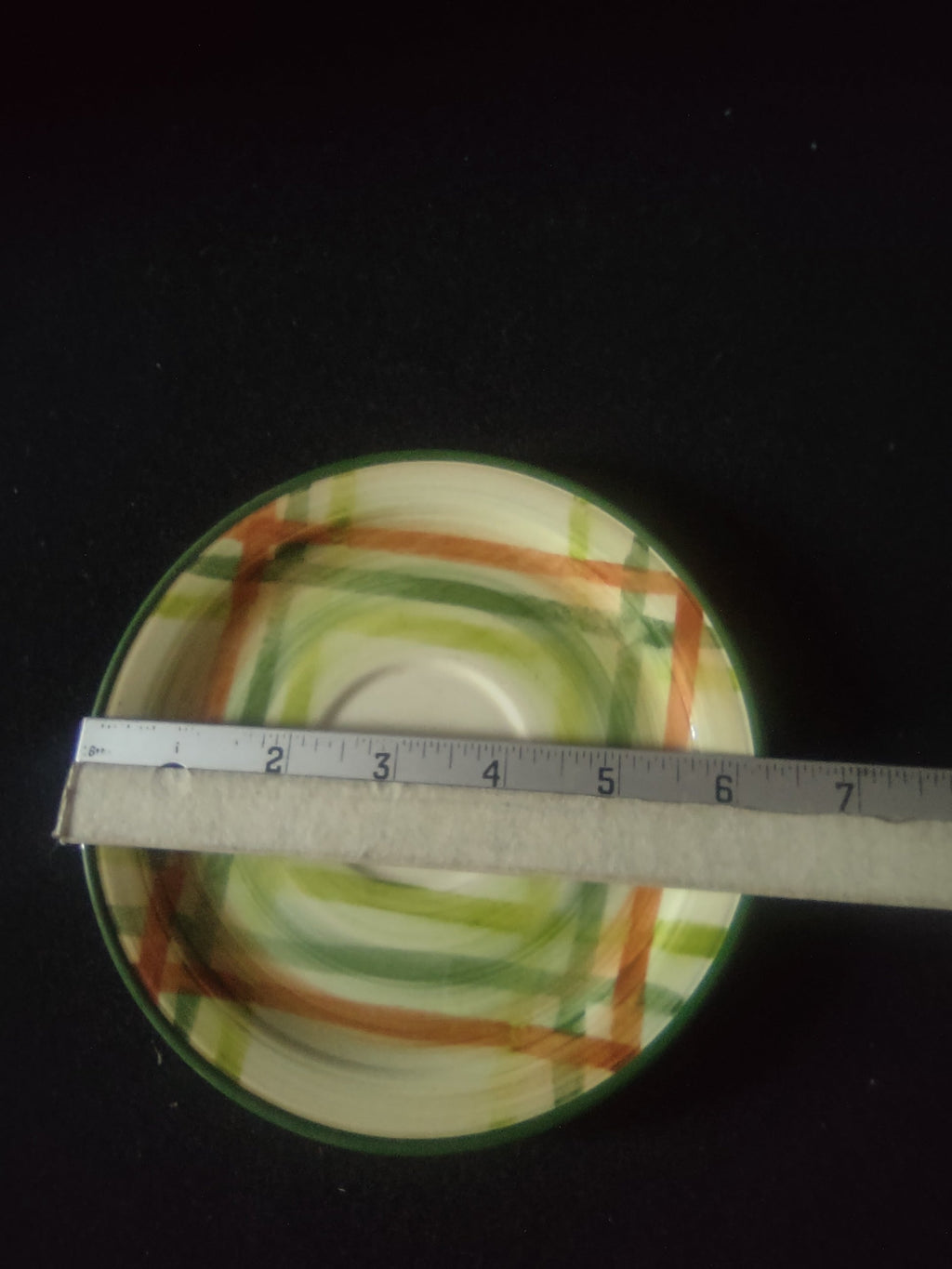 Vernon Kilns Tam O'Shanter saucer with ruler showing approx. 6 inch diameter