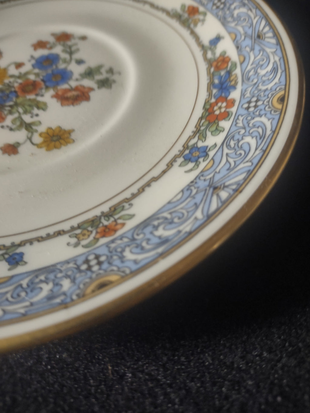 Coxon Belleek Boulevard saucer close-up of blue scrollwork border and floral garland