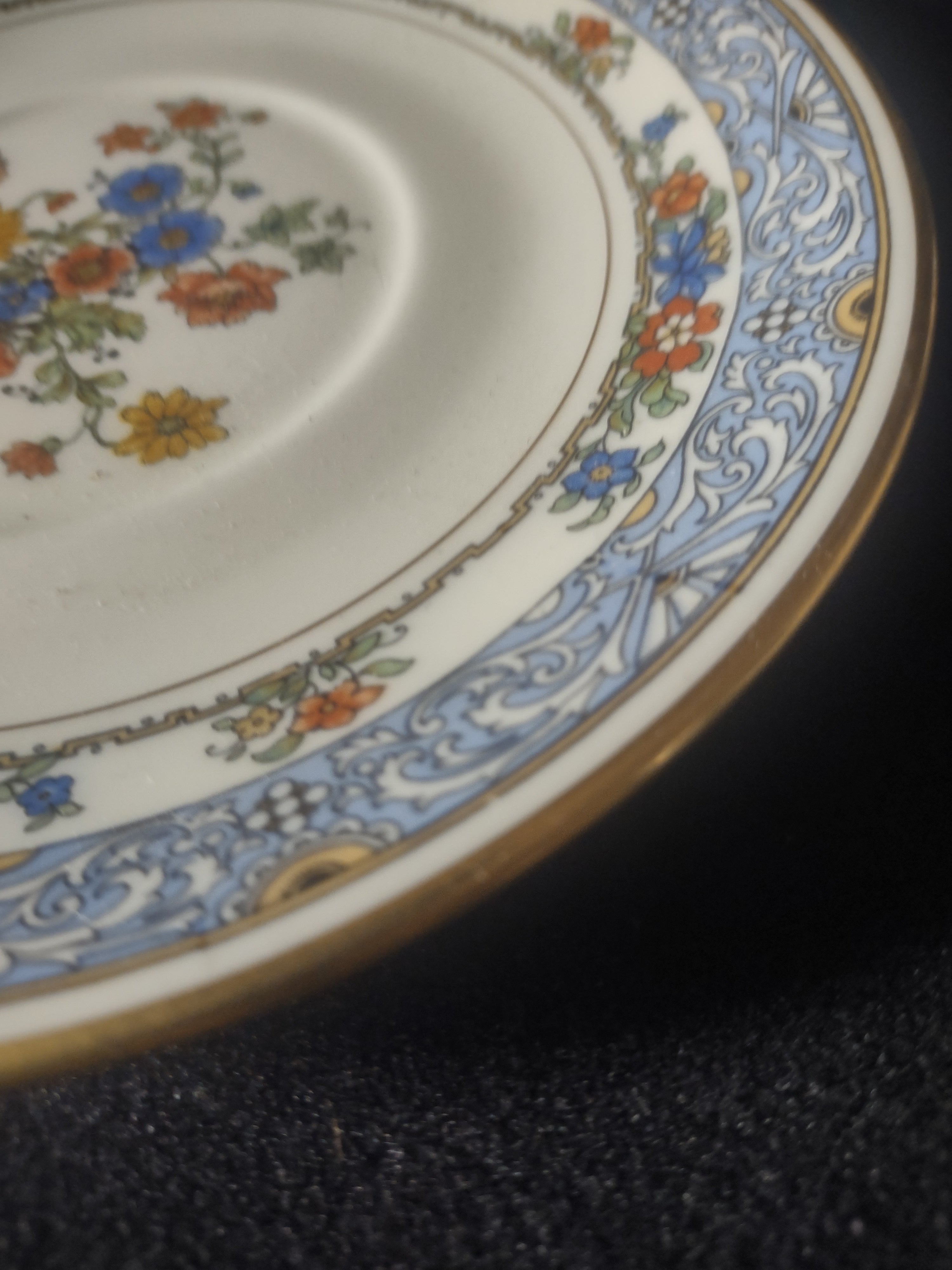 Coxon Belleek Boulevard saucer close-up of blue scrollwork border and floral garland