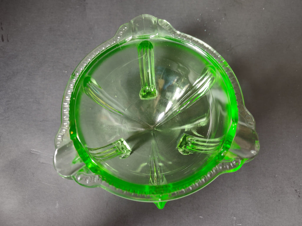 Vintage green uranium glass footed bowl glowing under UV black light showing uranium content