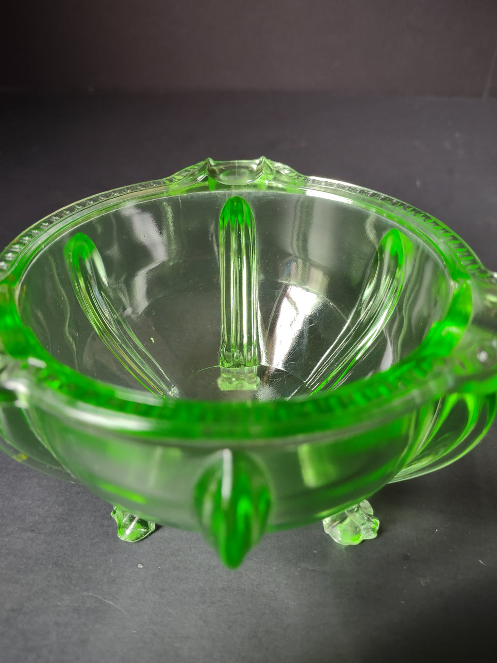 Vintage green uranium glass footed bowl side view under UV black light