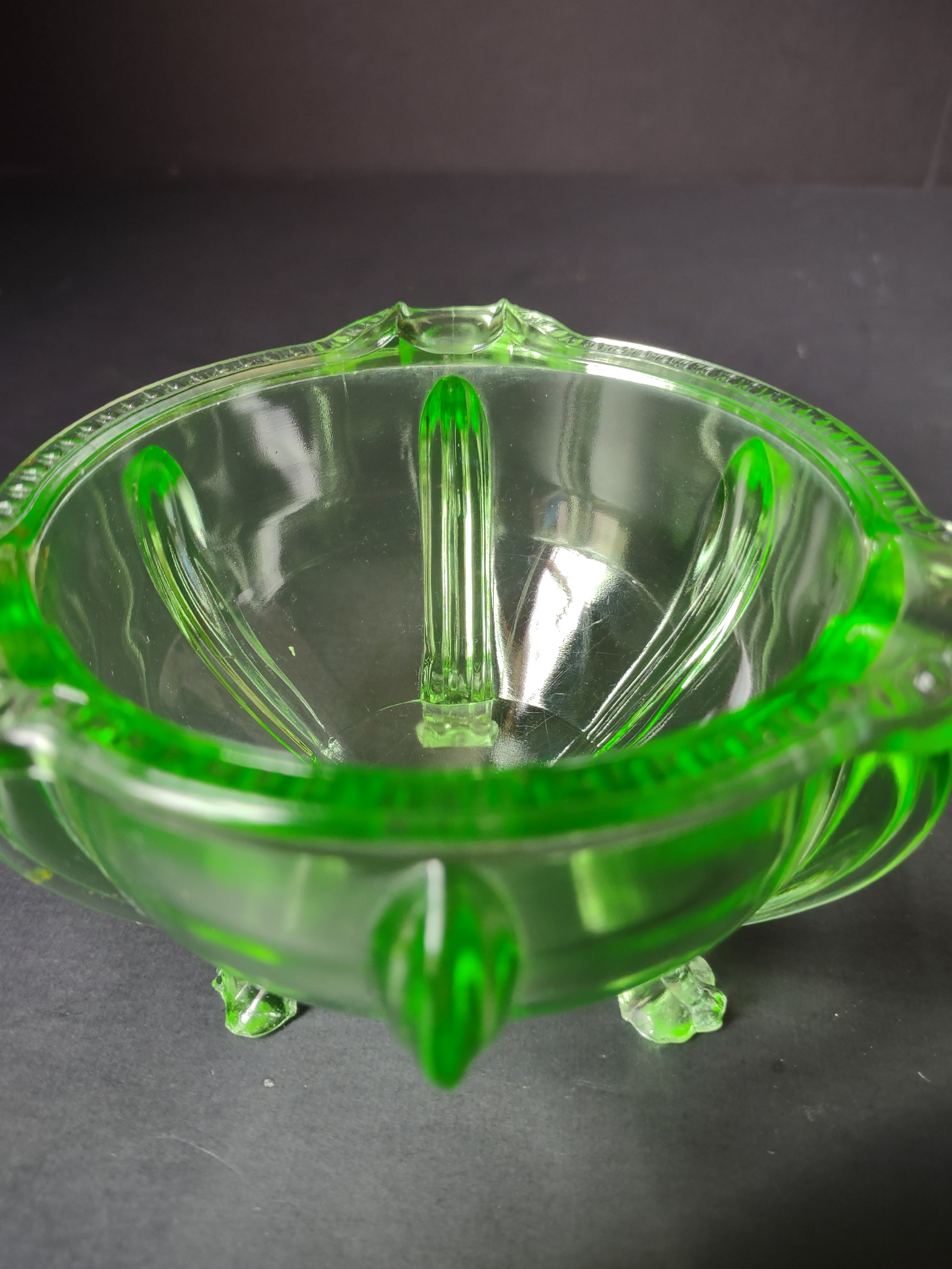 Vintage green uranium glass footed bowl side view under UV black light