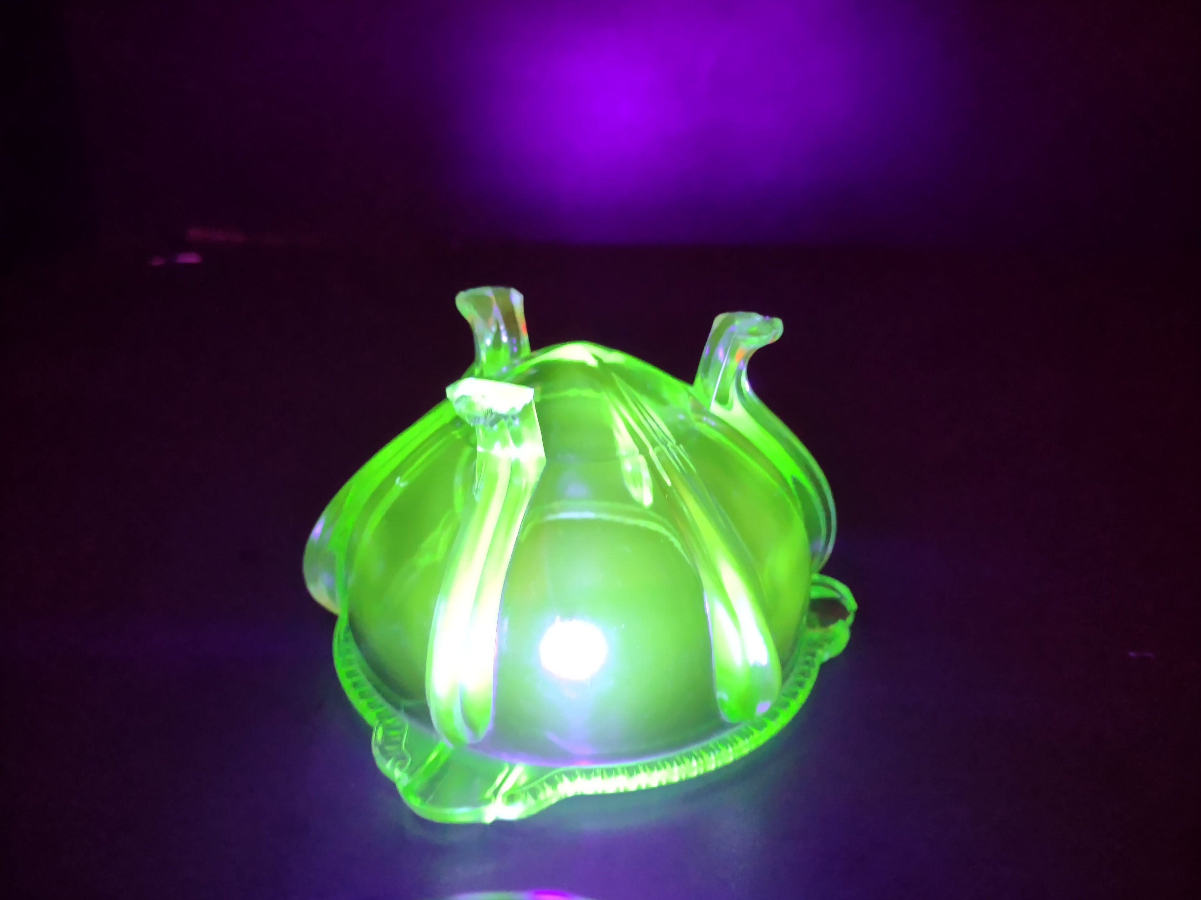 Vintage green uranium glass footed bowl with ruler showing approximately 5 inch diameter