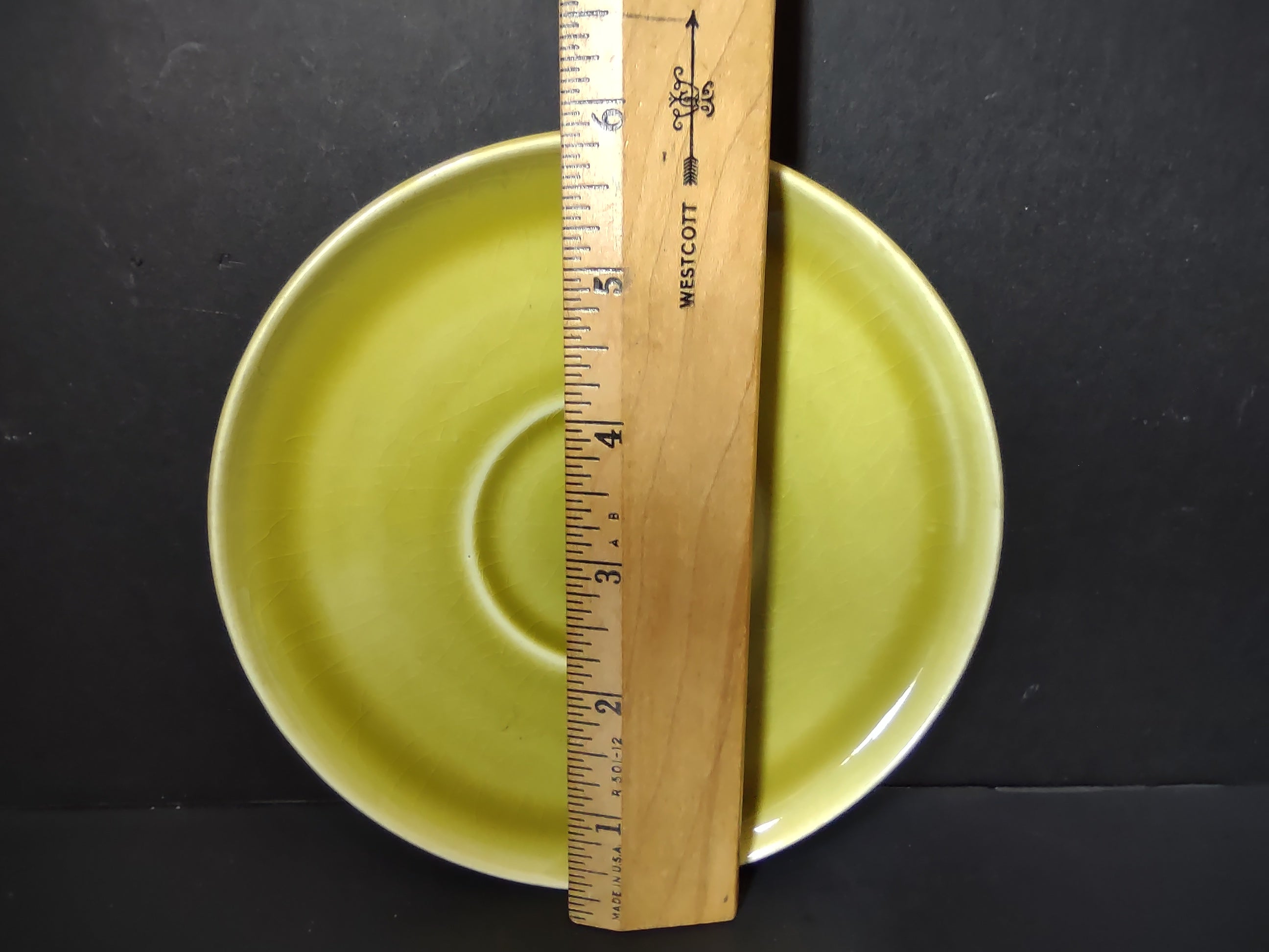 Vintage Russel Wright American Modern chartreuse saucer with ruler showing approximately 6 inch diameter