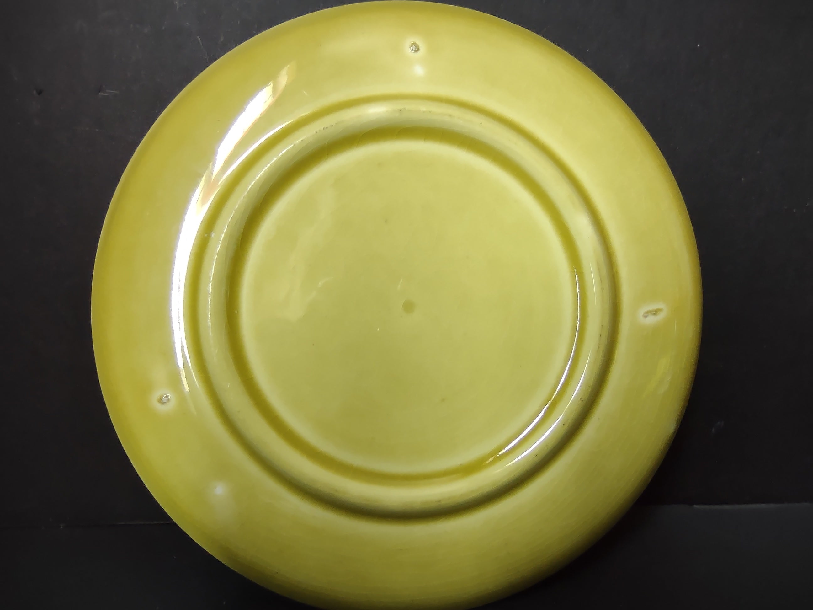 Vintage Russel Wright American Modern chartreuse saucer back view showing foot ring and glaze