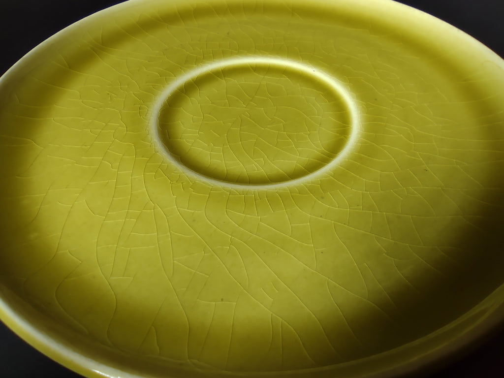 Vintage Russel Wright American Modern chartreuse saucer close-up showing crazing in the glaze