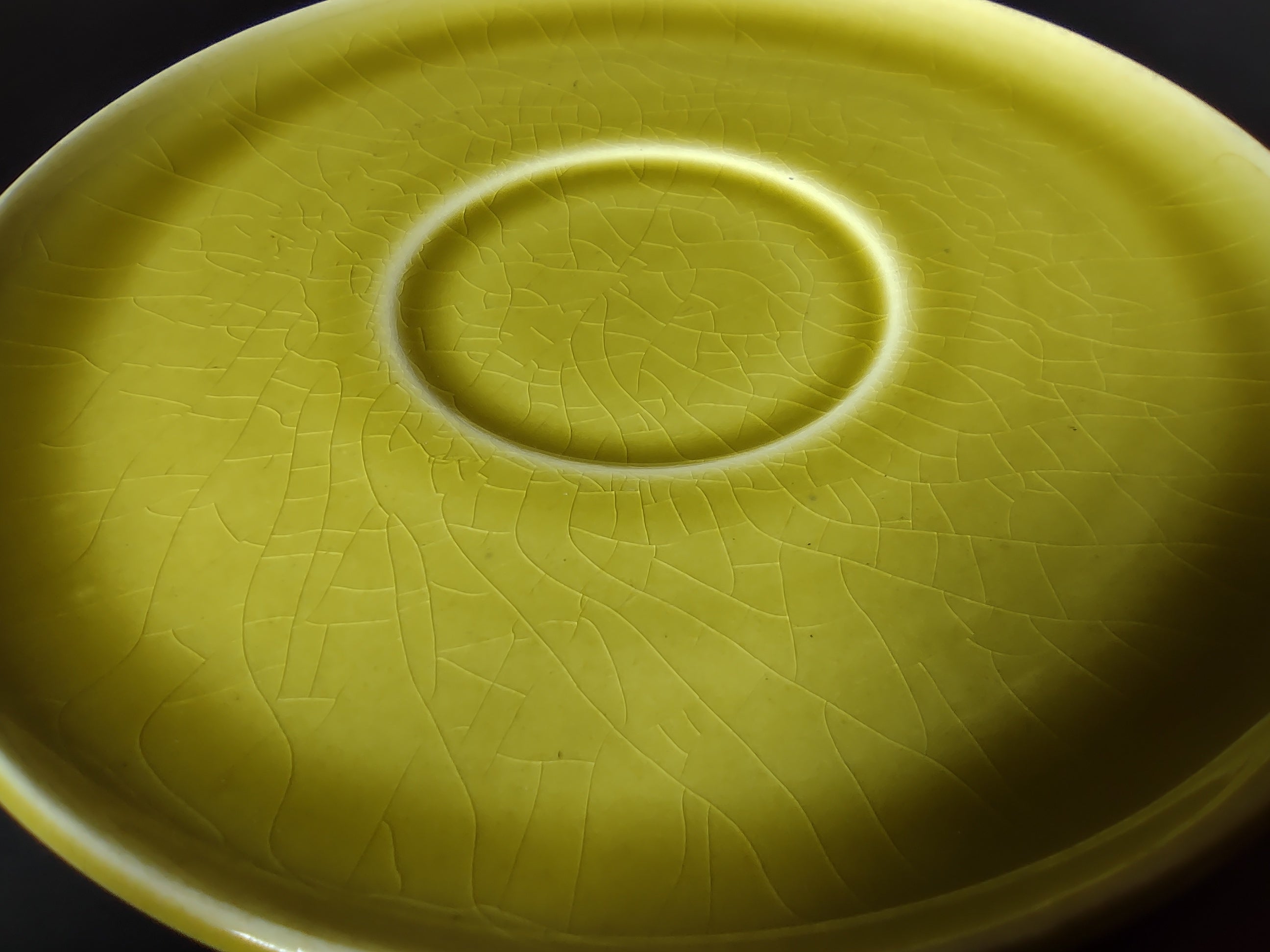 Vintage Russel Wright American Modern chartreuse saucer close-up showing crazing in the glaze