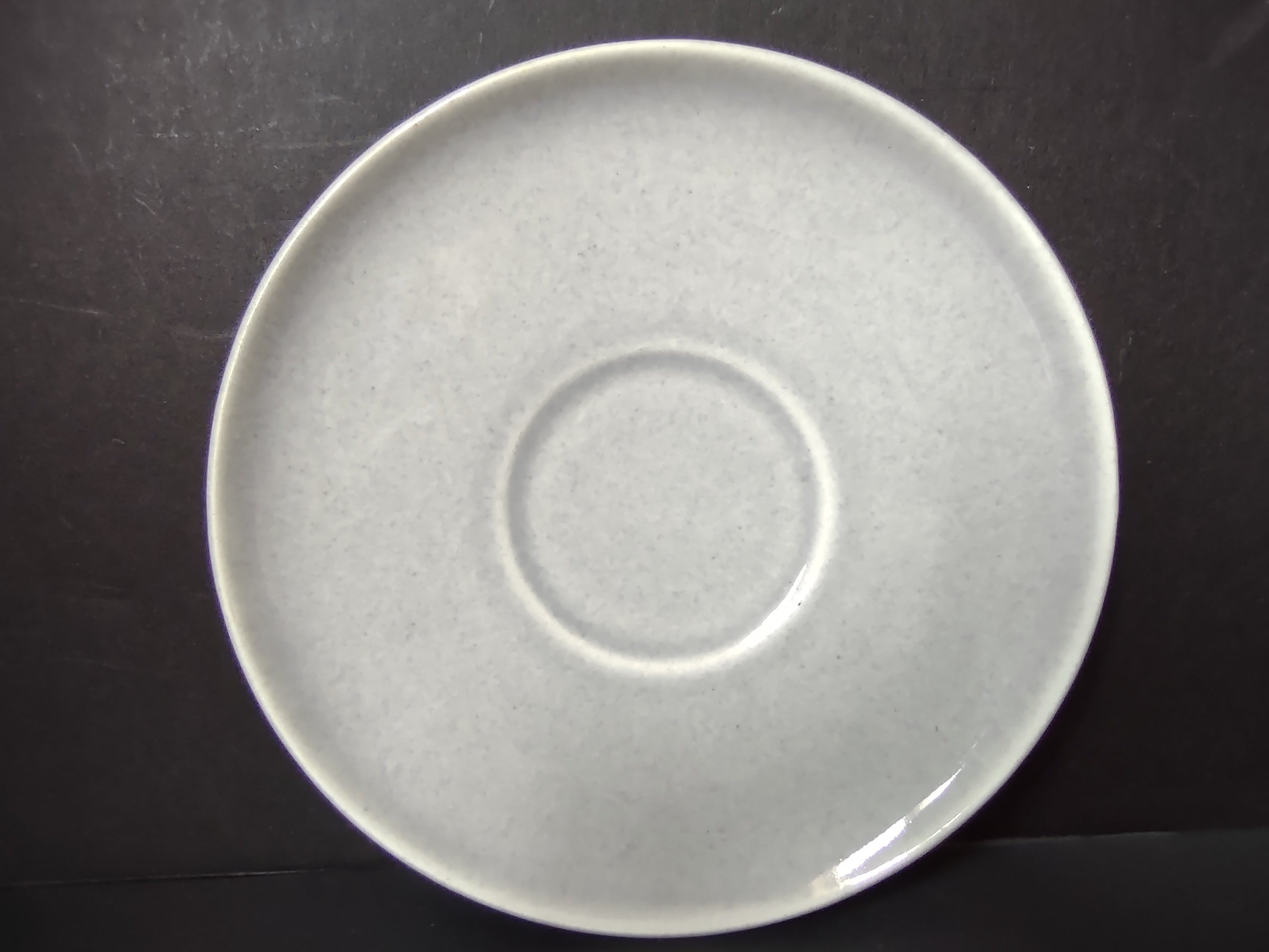 Vintage white unbranded saucer back view showing plain off-white glaze and concentric rings