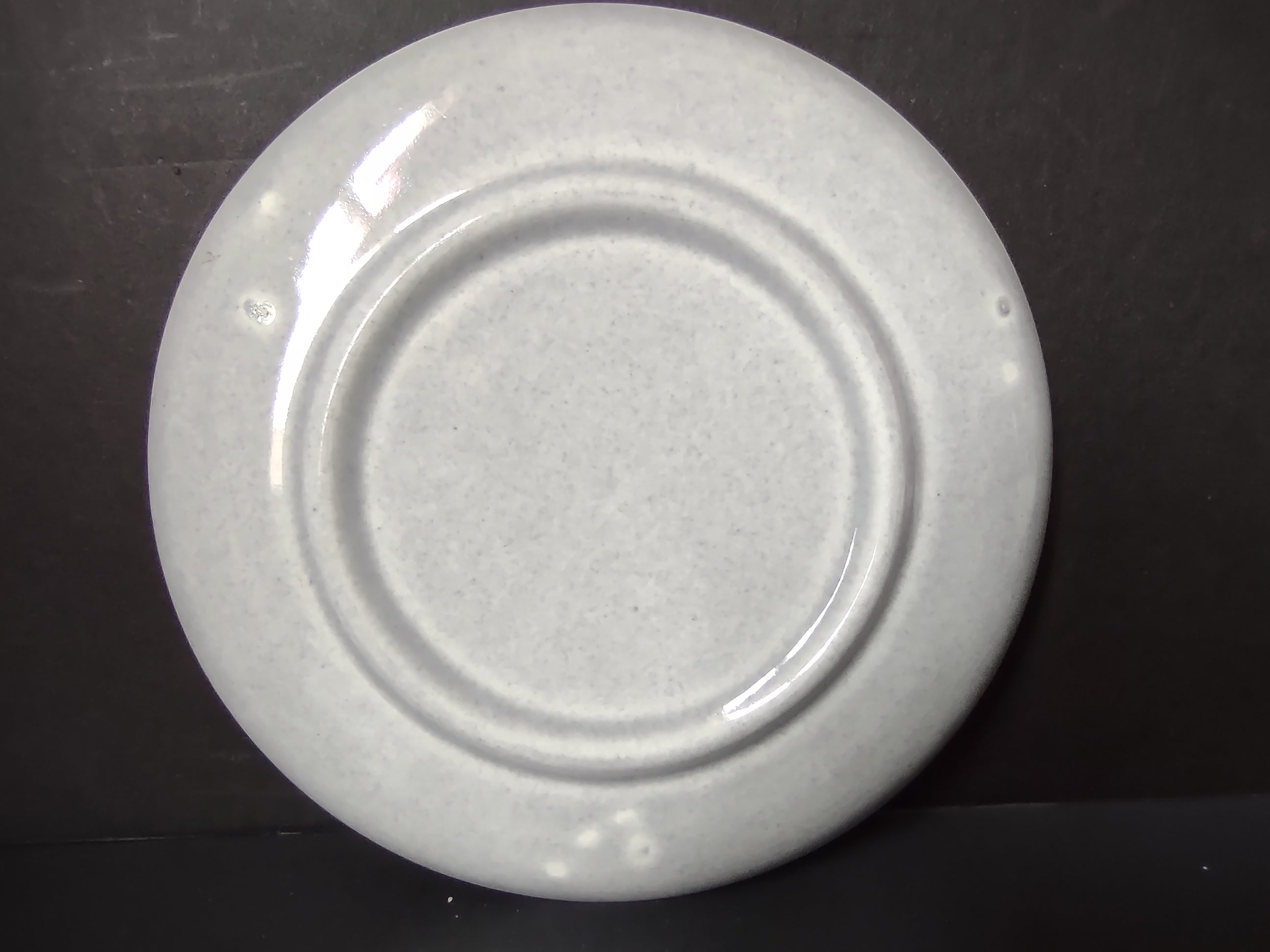 Vintage white unbranded saucer with ruler showing approximately 6 inch diameter