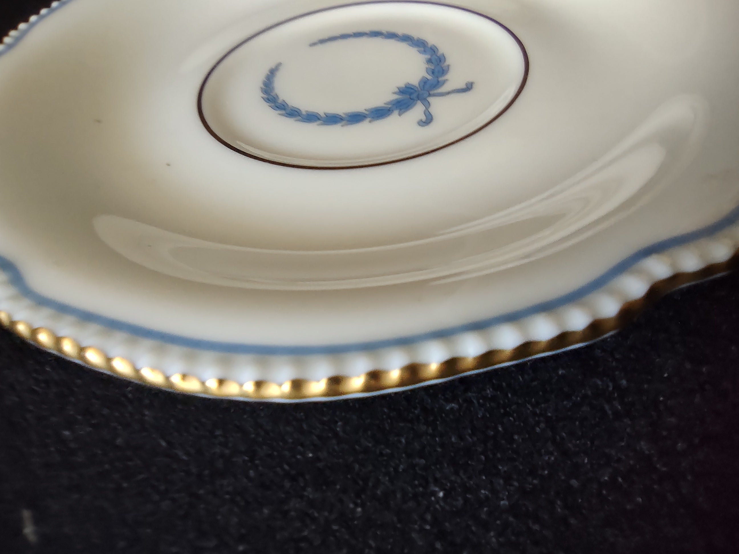 Saucer detail showing blue laurel wreath center and beaded scalloped edge