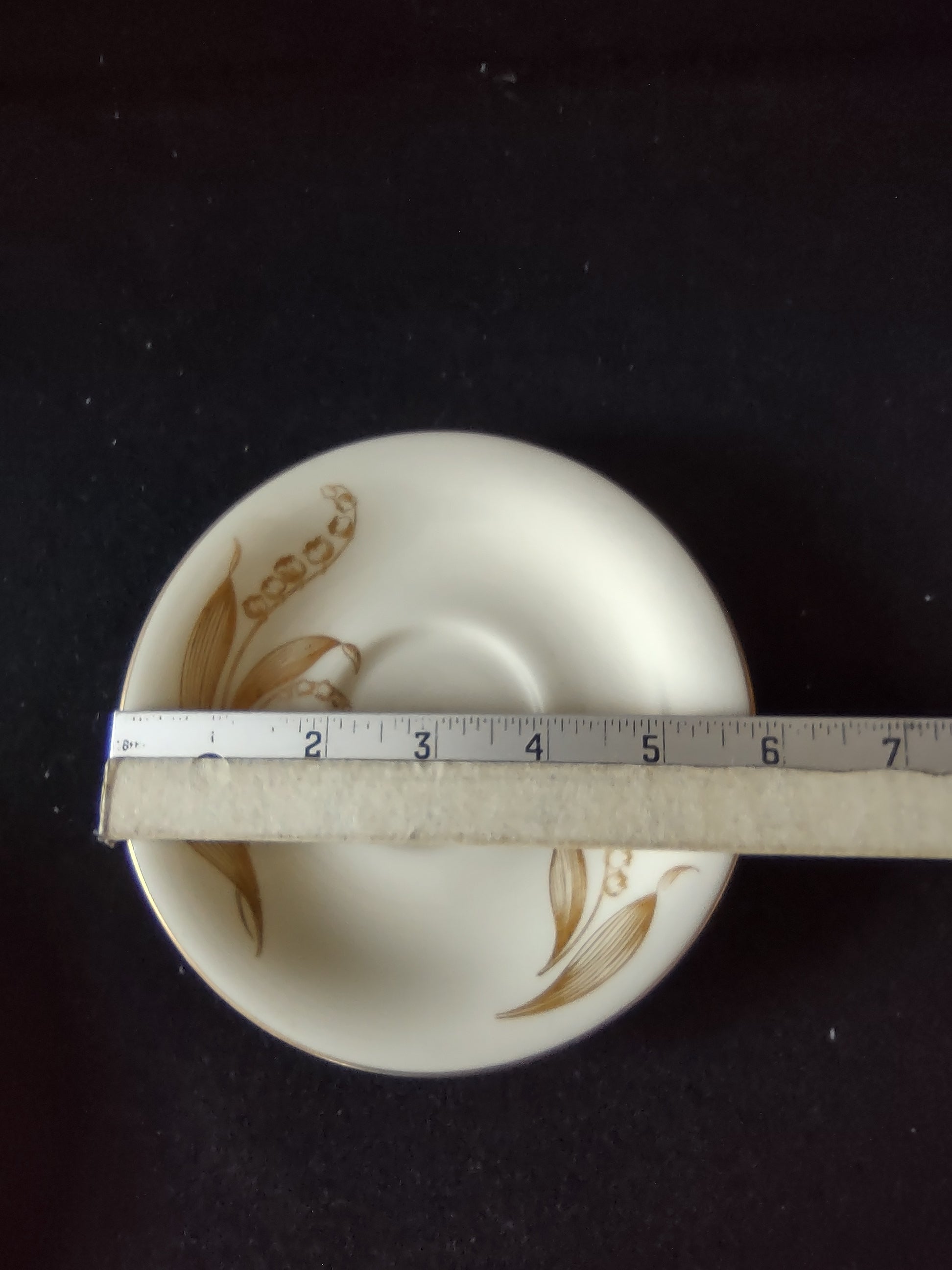 Castleton China Gold Lily of the Valley saucer top view on display stand
