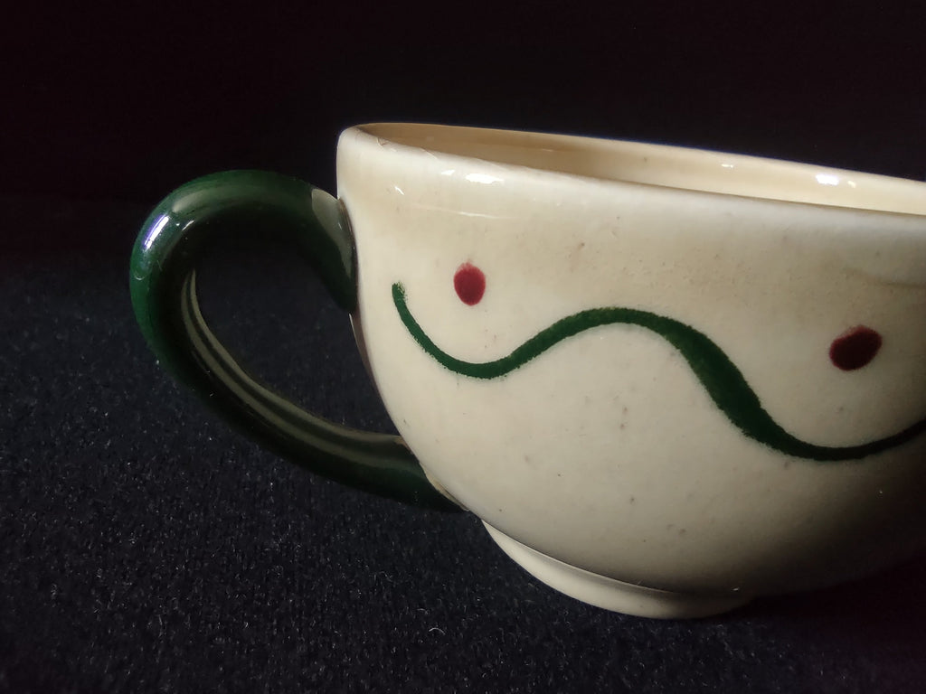 Close-up of Metlox Poppytrail Navajo cup showing green wave and red dot pattern detail