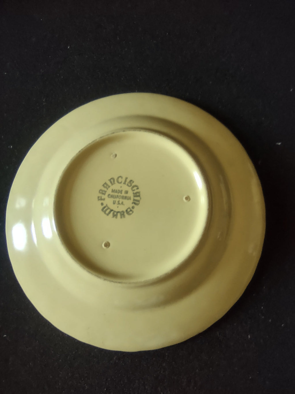 Vintage Franciscan Ware Swirl yellow plate on display stand, front view