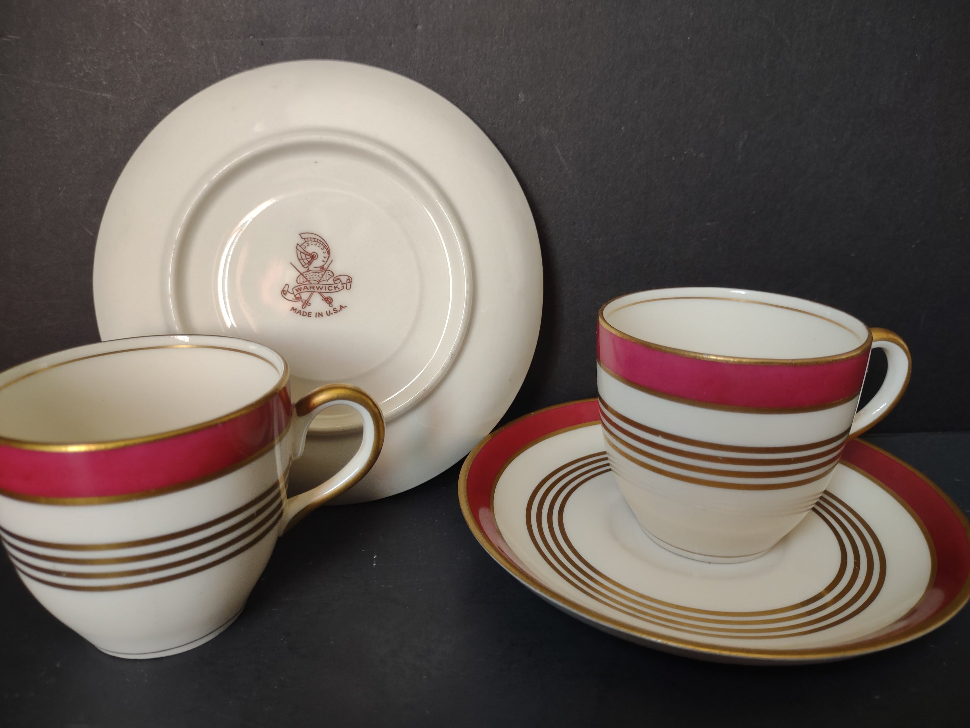 Two Warwick China crimson red gold demitasse cup and saucer sets side by side
