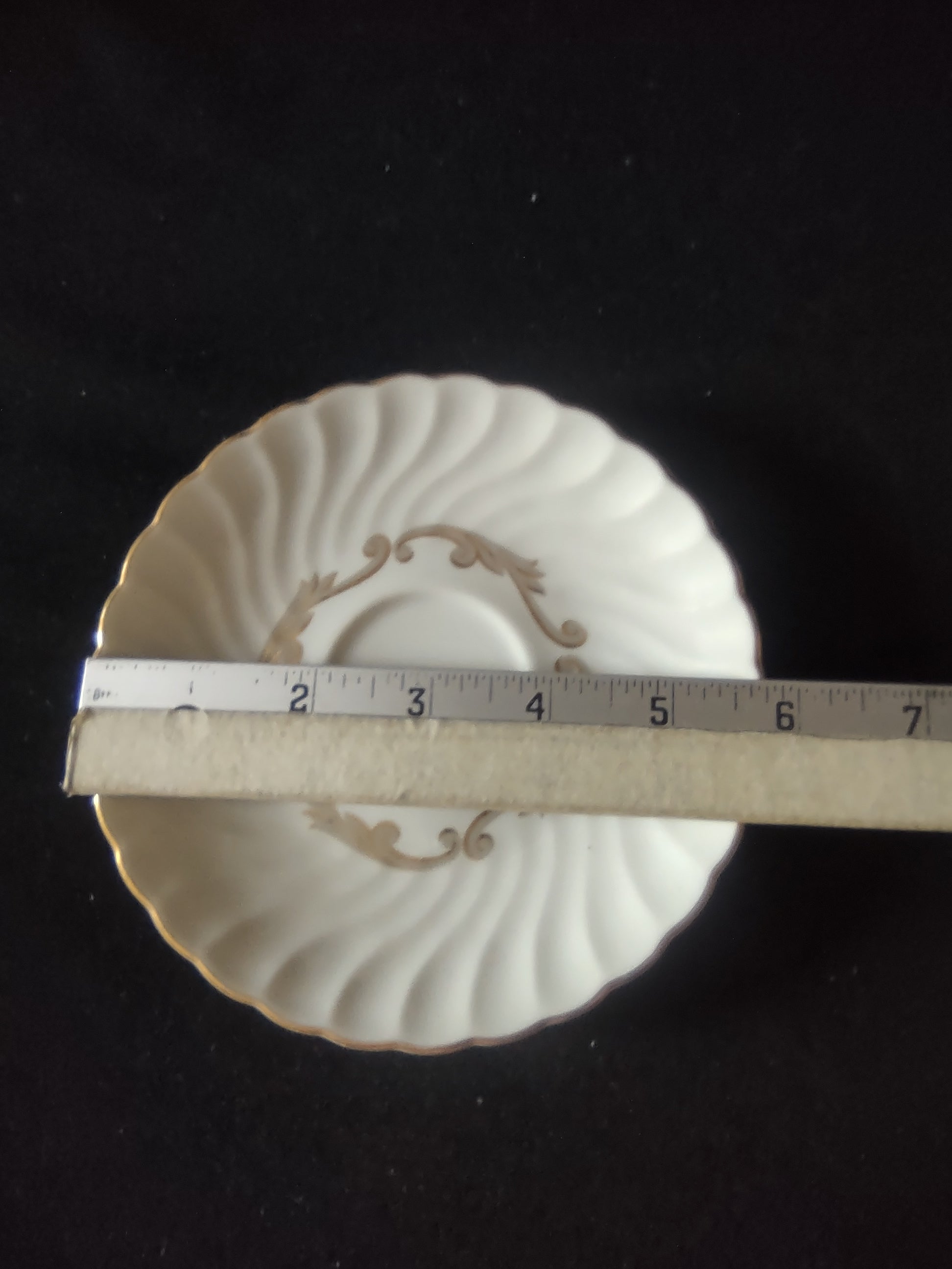 Rim and fluted body detail showing discoloration near cup well