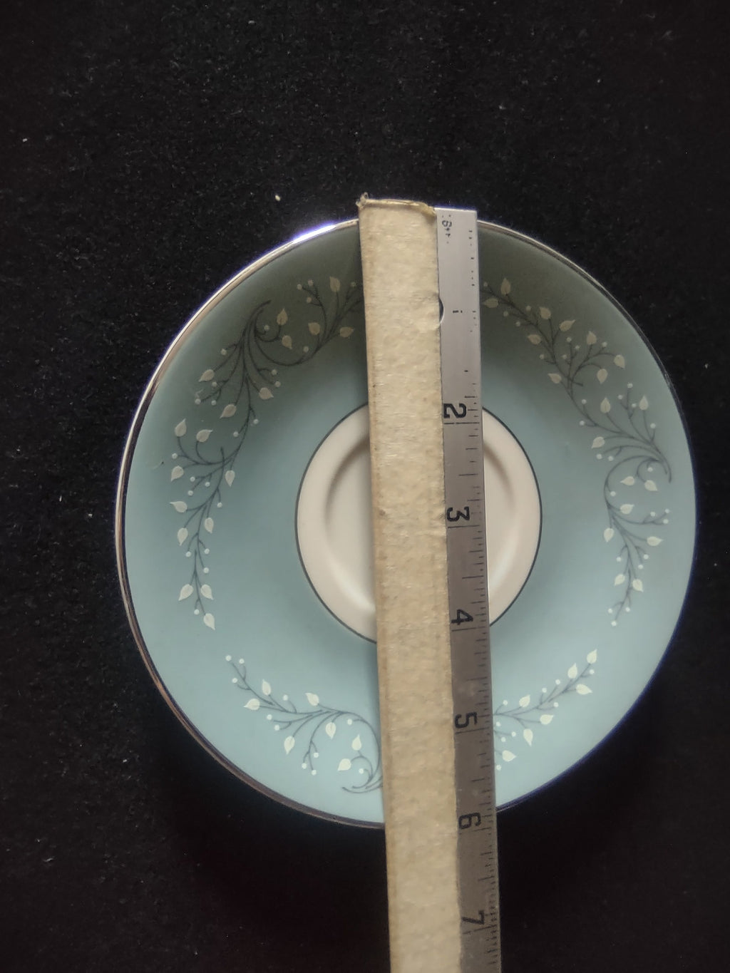 Saucer detail showing white leaf sprig pattern on blue ground