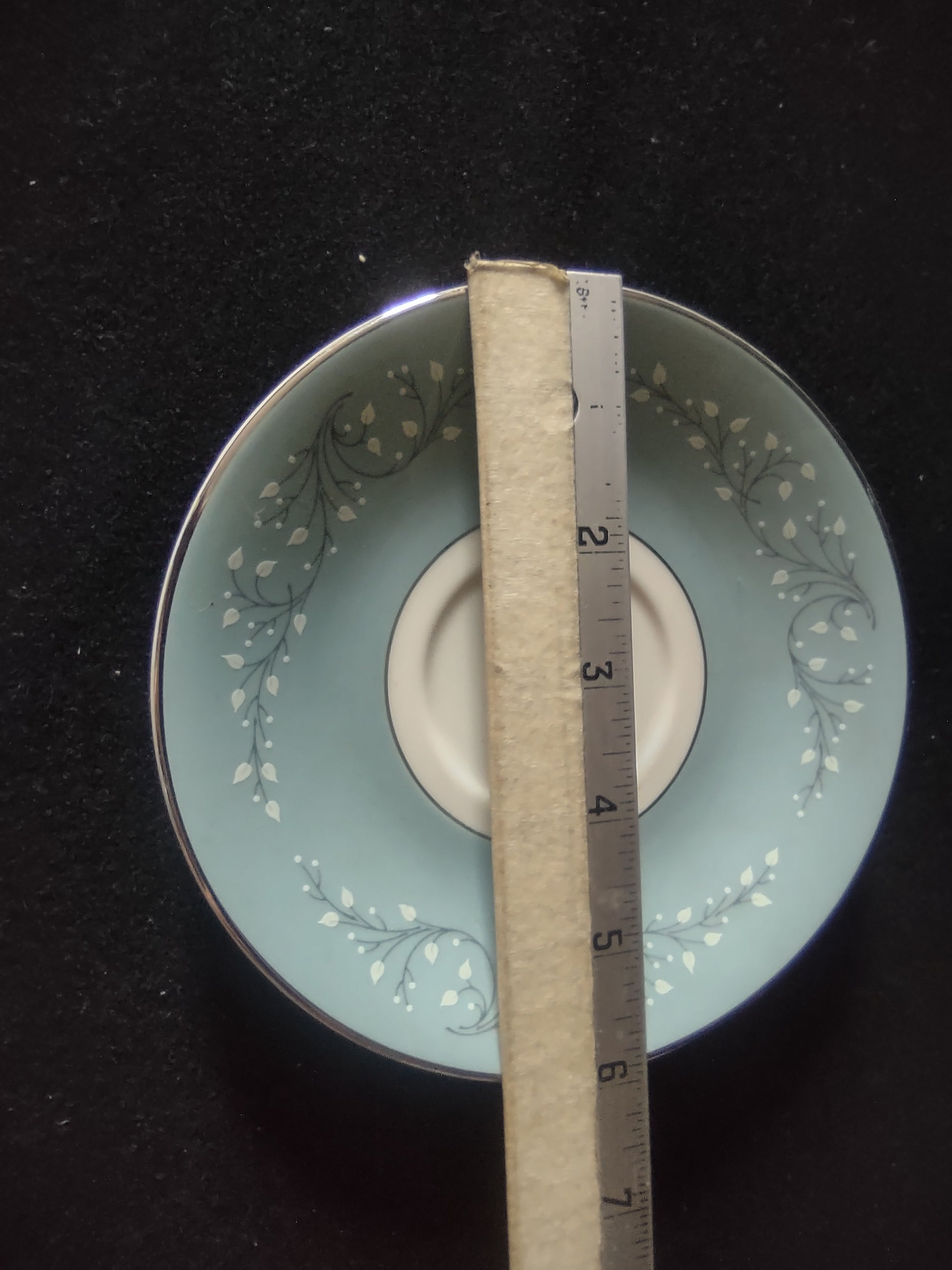 Saucer detail showing white leaf sprig pattern on blue ground
