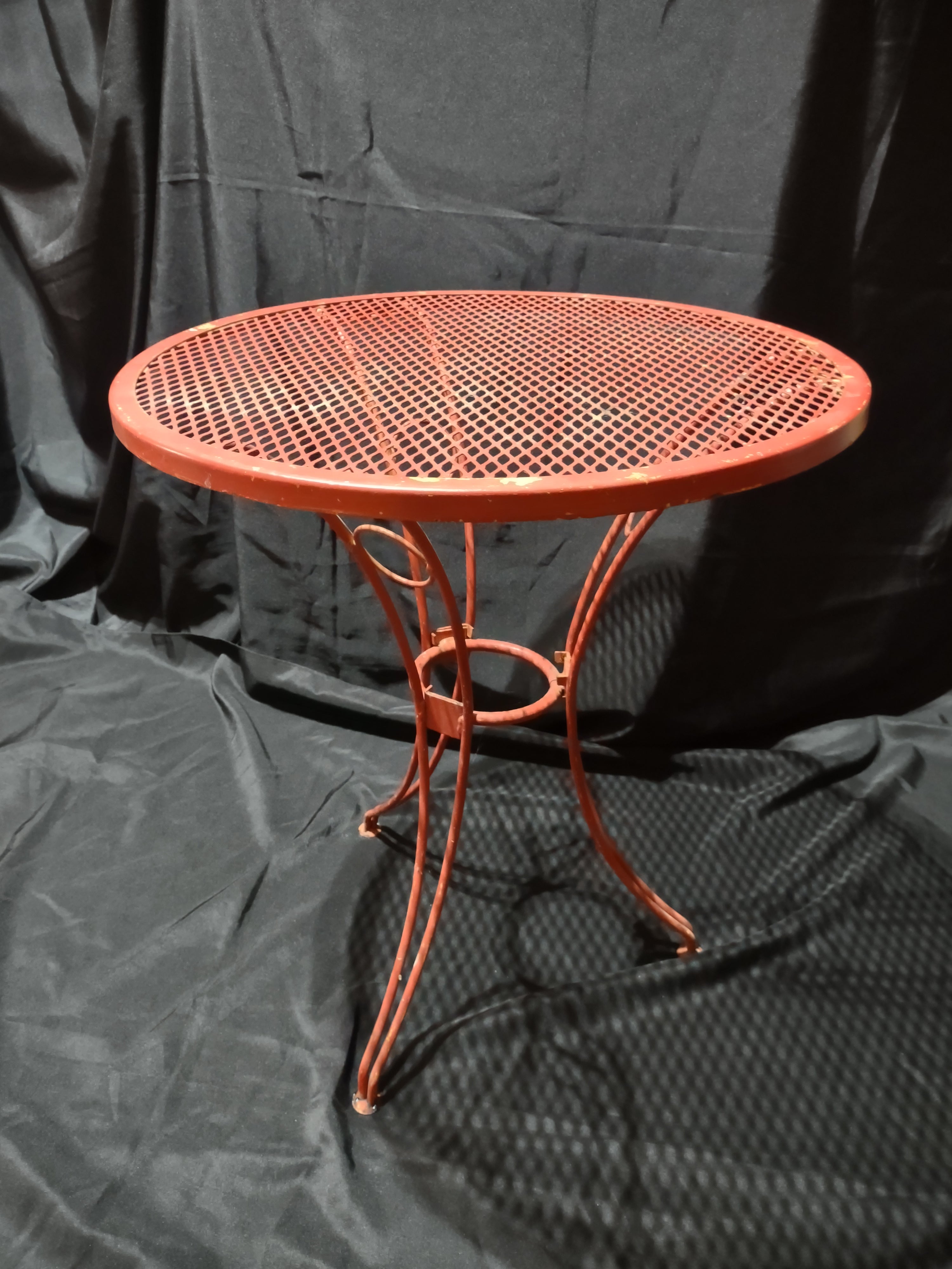 Vintage red metal mesh bistro table - curved leg detail and foot