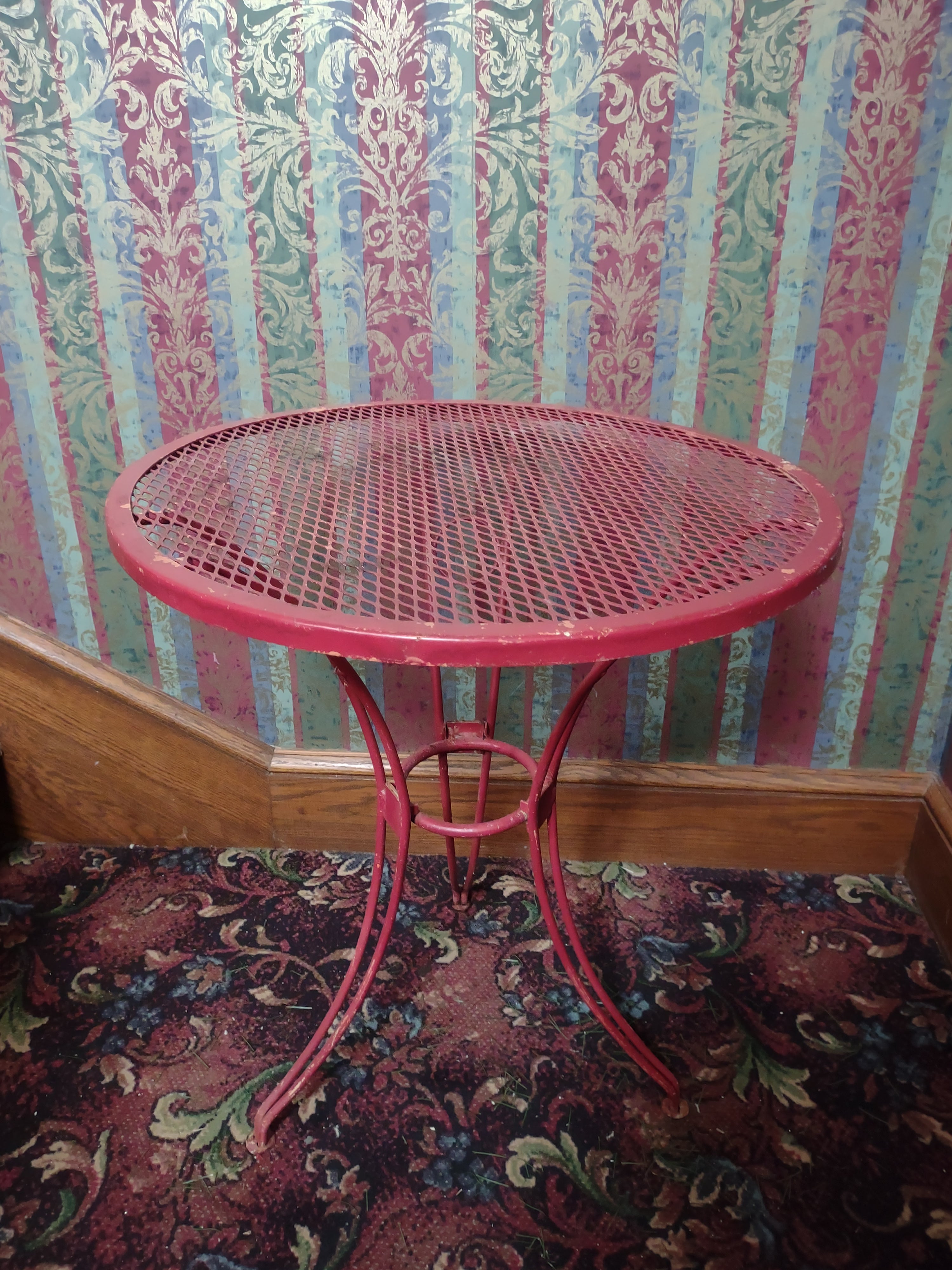 Vintage red metal mesh bistro table - top view showing mesh surface and wear