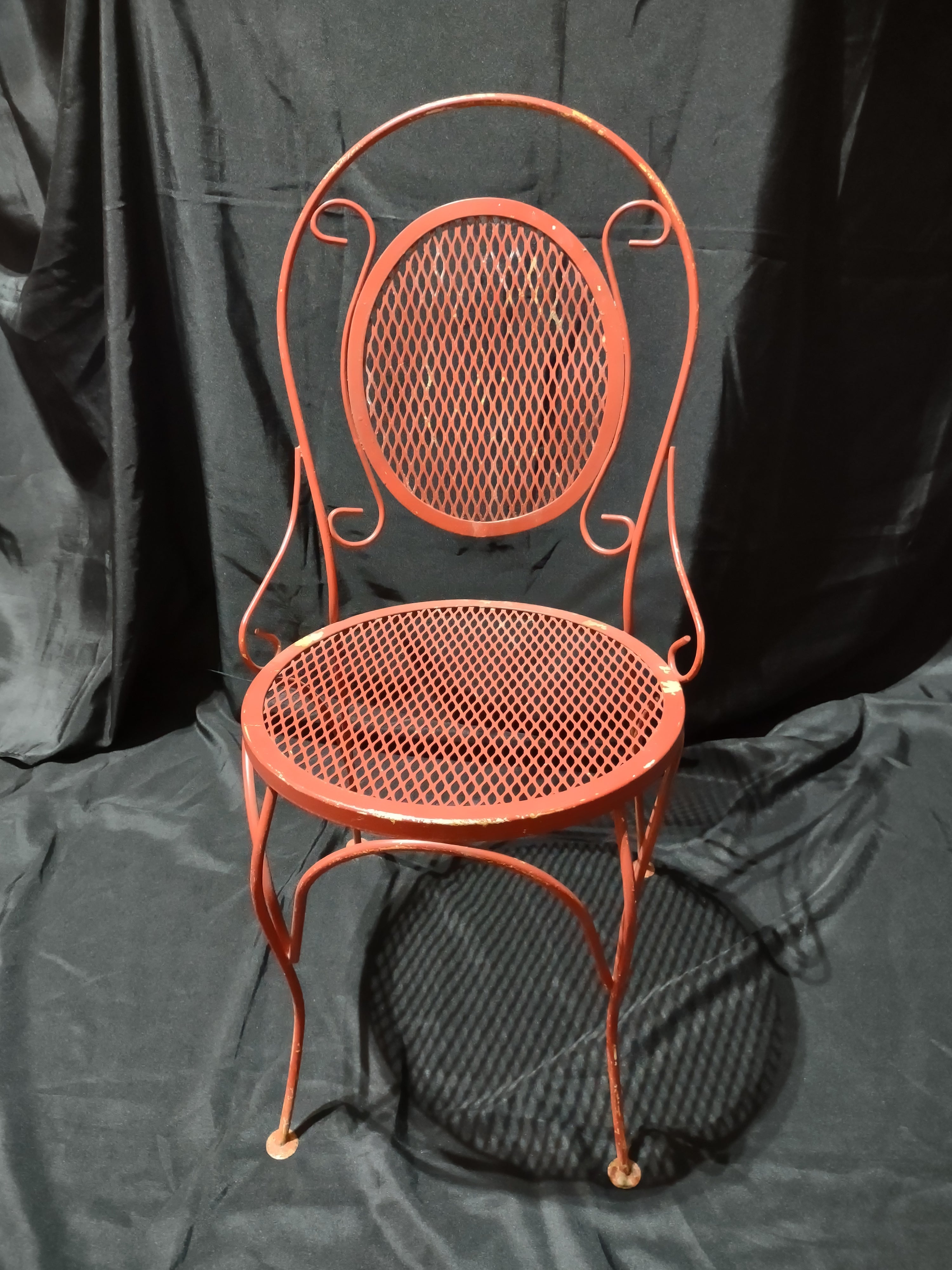 Vintage red metal mesh bistro chair - overhead view showing seat and back detail