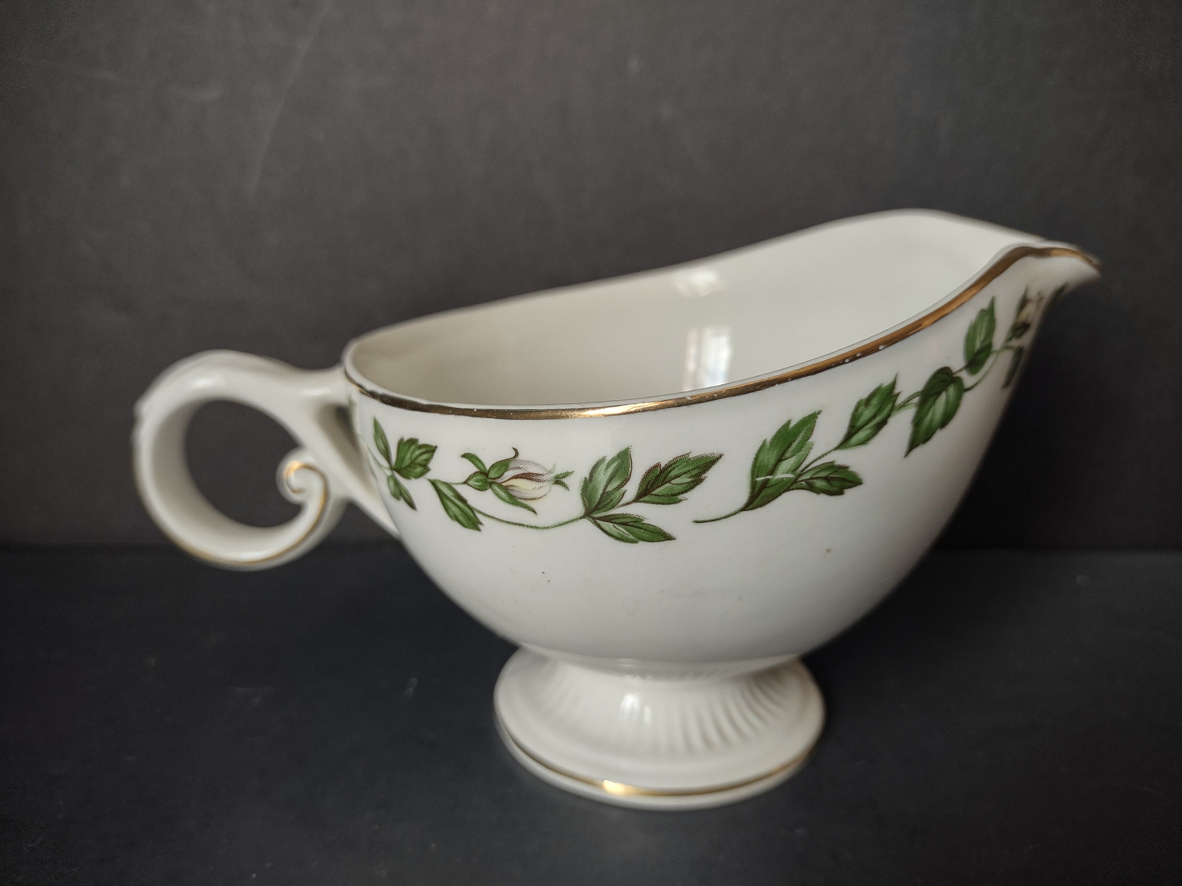 Vintage green ivy garland gold trim porcelain gravy boat - front left view showing full pattern