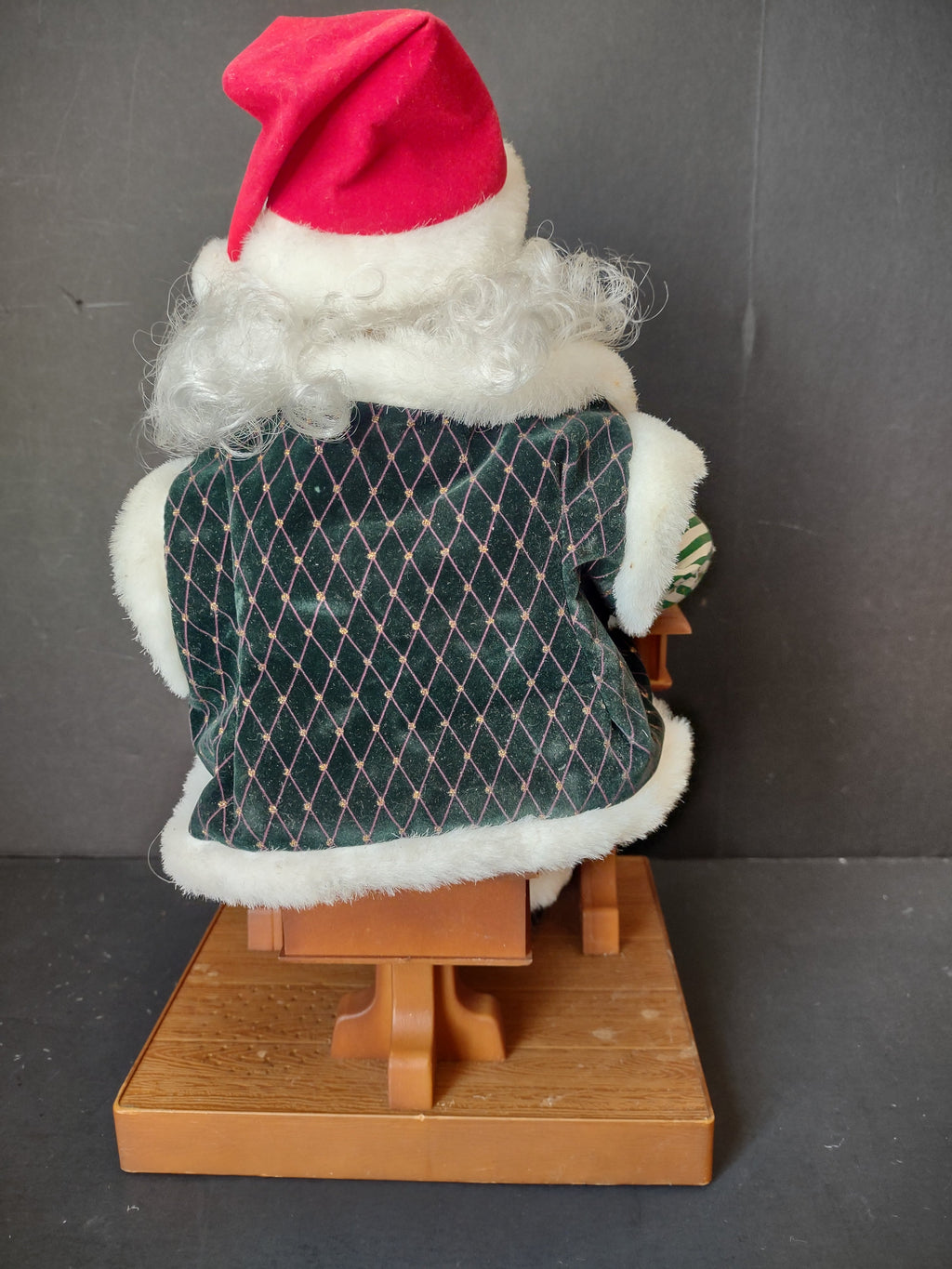 Vintage animated Santa Claus seated at school desk - front view showing face, glasses, and green velvet coat