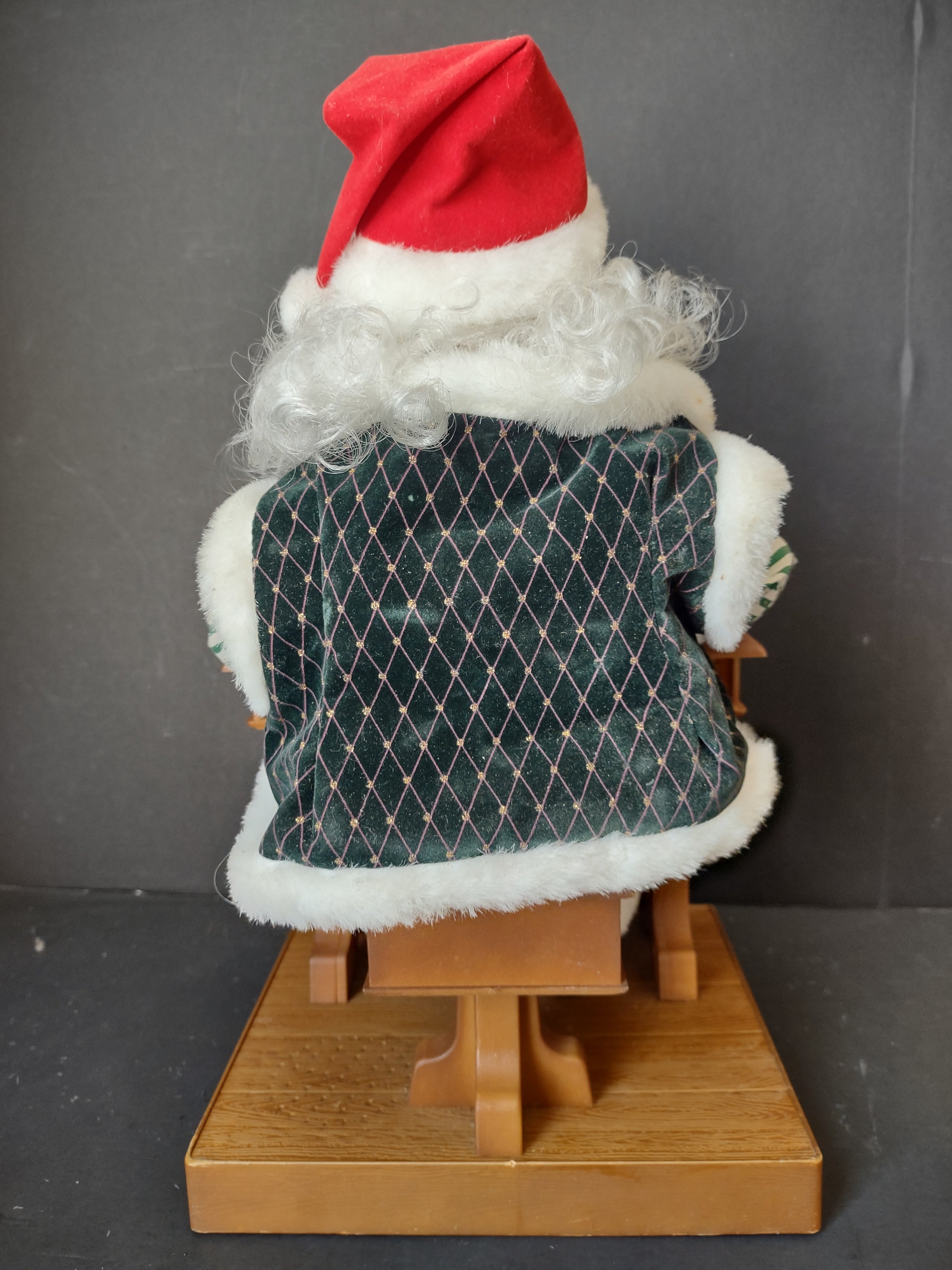 Vintage animated Santa Claus at school desk - close-up of base showing wood-grain texture