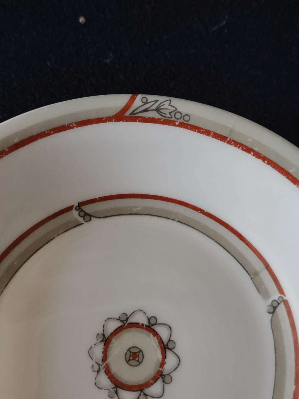 Front of Theodore Haviland New York plate showing red-orange double bands and Art Deco medallion center with platinum leaf sprigs