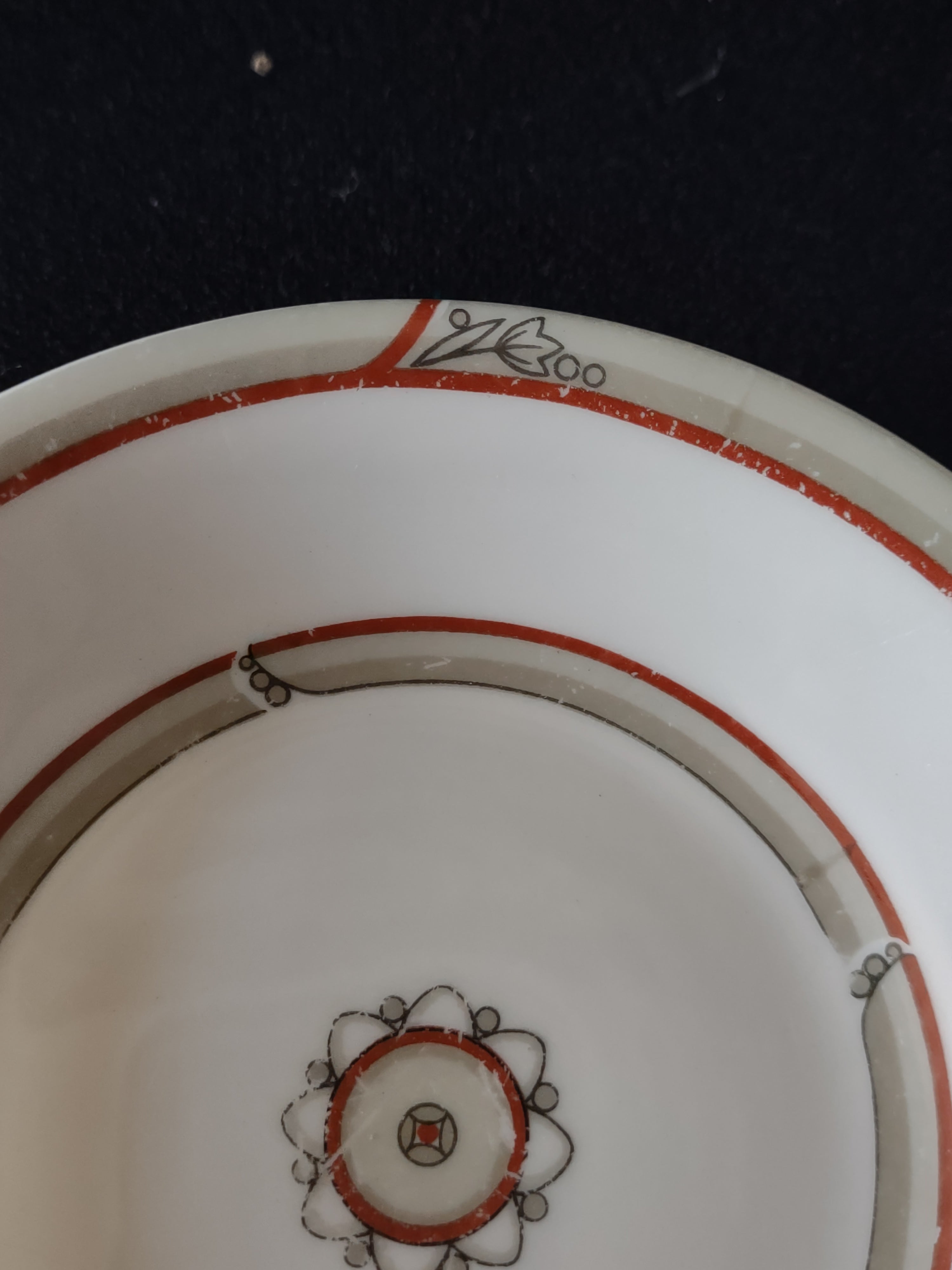 Front of Theodore Haviland New York plate showing red-orange double bands and Art Deco medallion center with platinum leaf sprigs