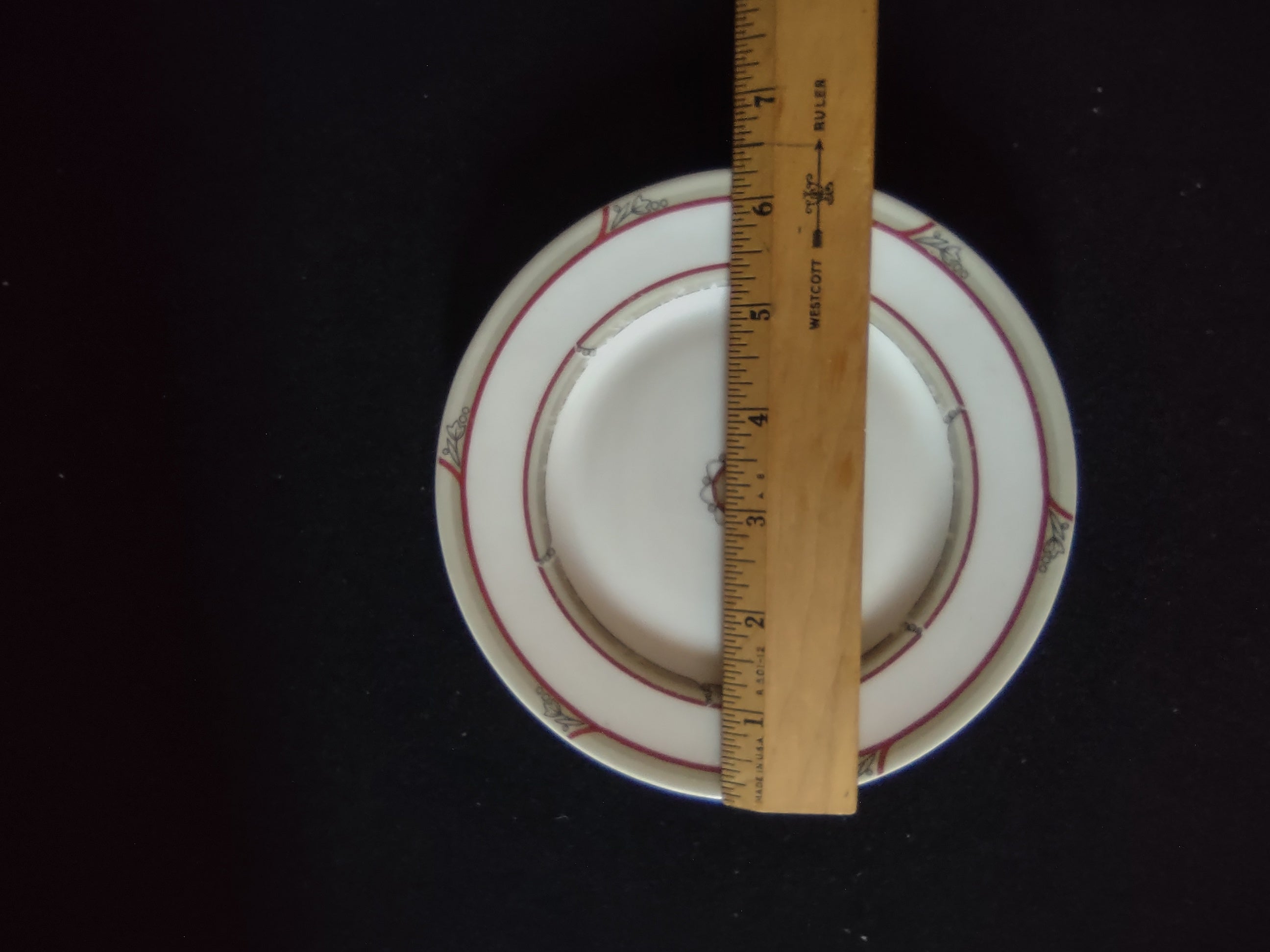 Close-up of red double bands showing age-appropriate crazing and handwritten notation on rim