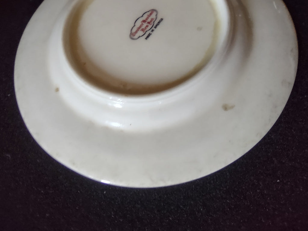 Close-up of geometric flower medallion center with red circle and diamond motif on off-white porcelain
