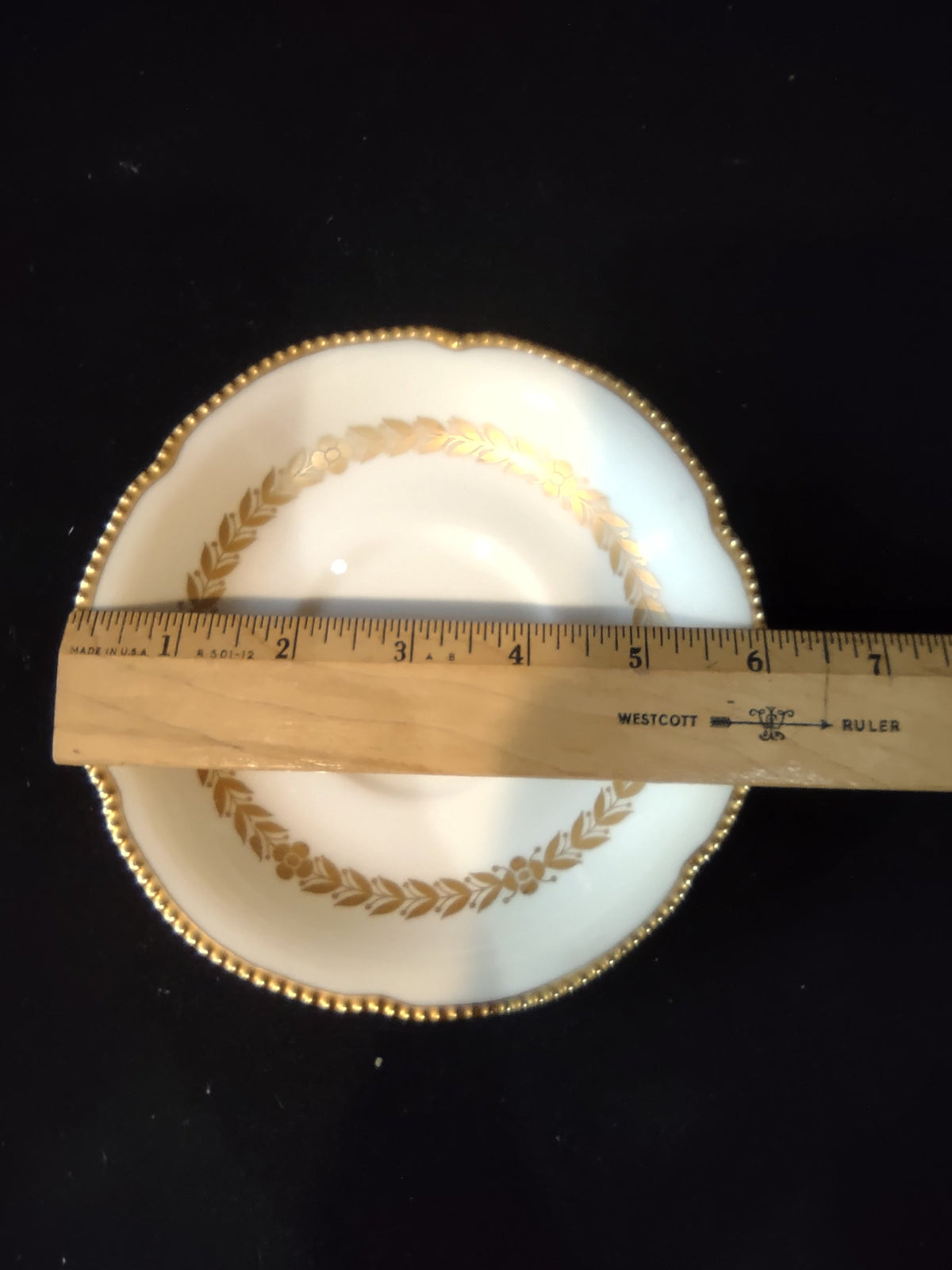 Castleton China Laurel saucer top view with ruler showing approx 6 inch diameter, gold beaded rim and laurel garland