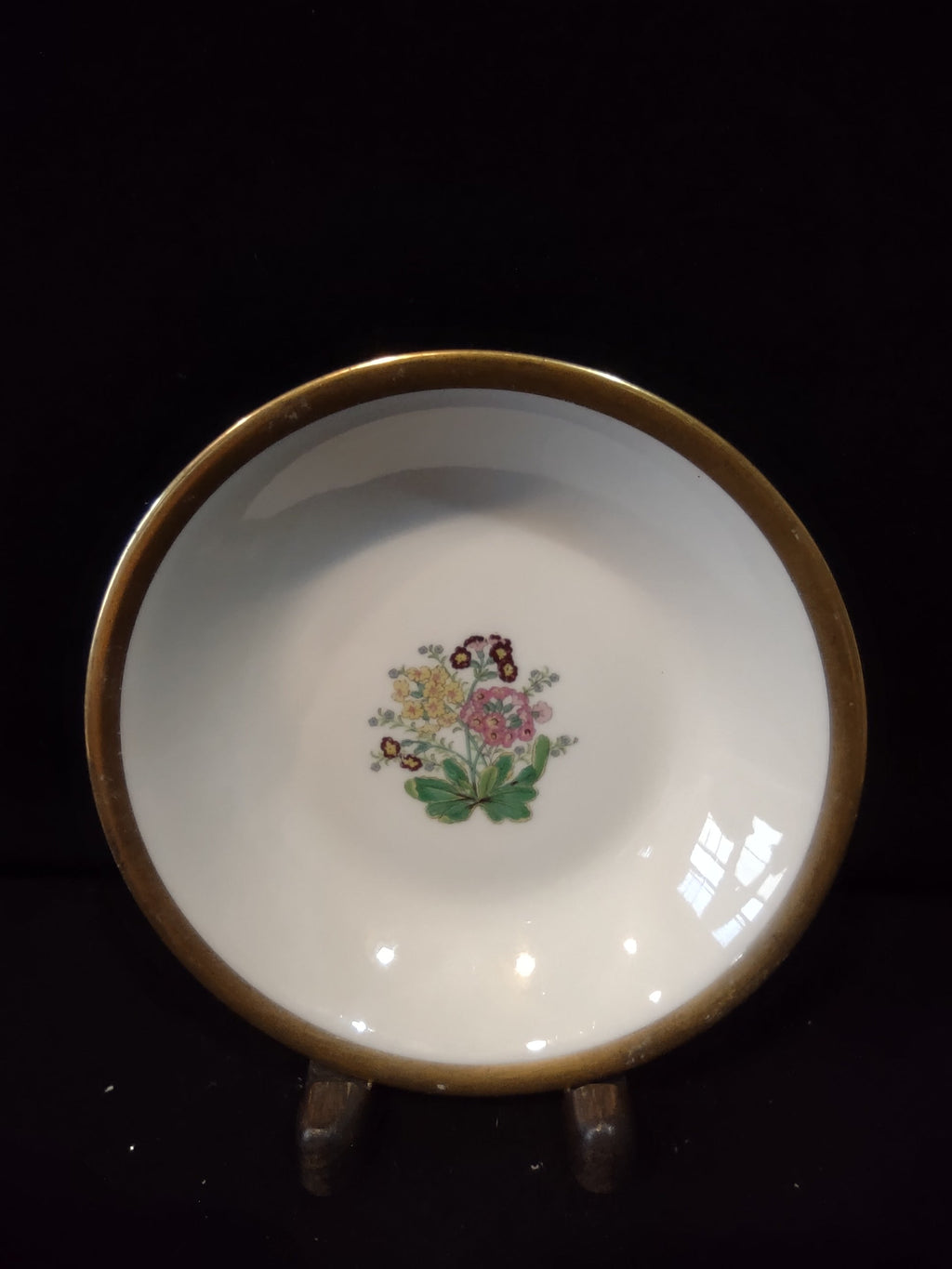 Vintage Theodore Haviland New York saucer with multicolor floral bouquet center motif — yellow, pink, and burgundy flowers with green leaves — and wide gold band rim on white porcelain