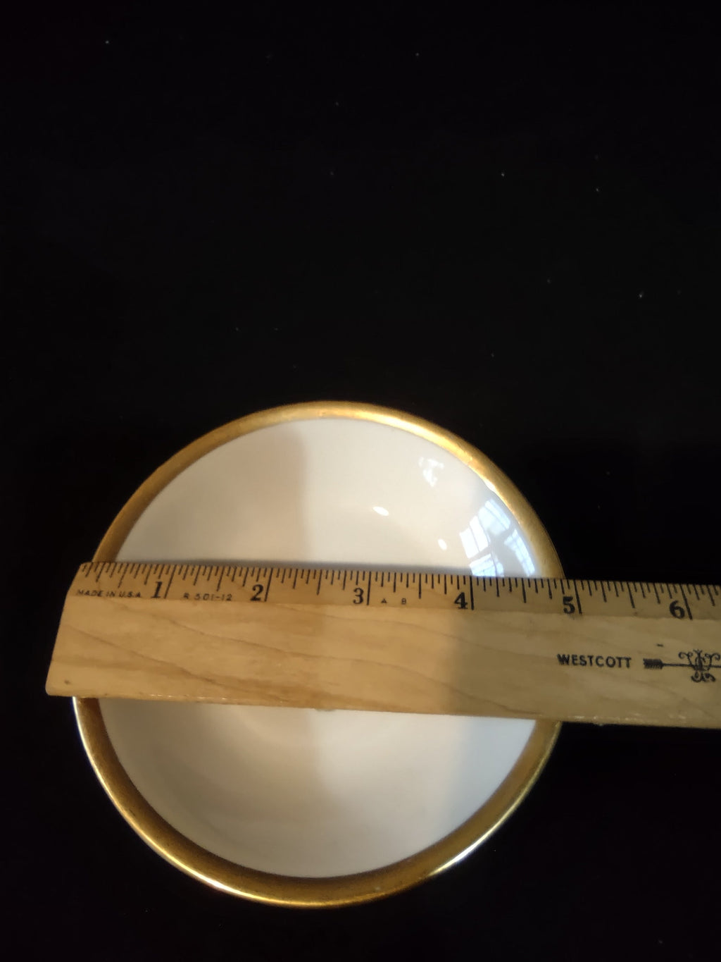 Vintage Theodore Haviland New York saucer with ruler showing approximately 4 inch diameter, wide gold band rim on white porcelain