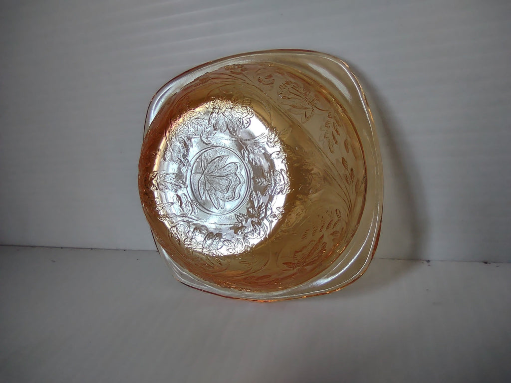 Exterior base view of marigold carnival glass square bowl showing embossed grape pattern detail