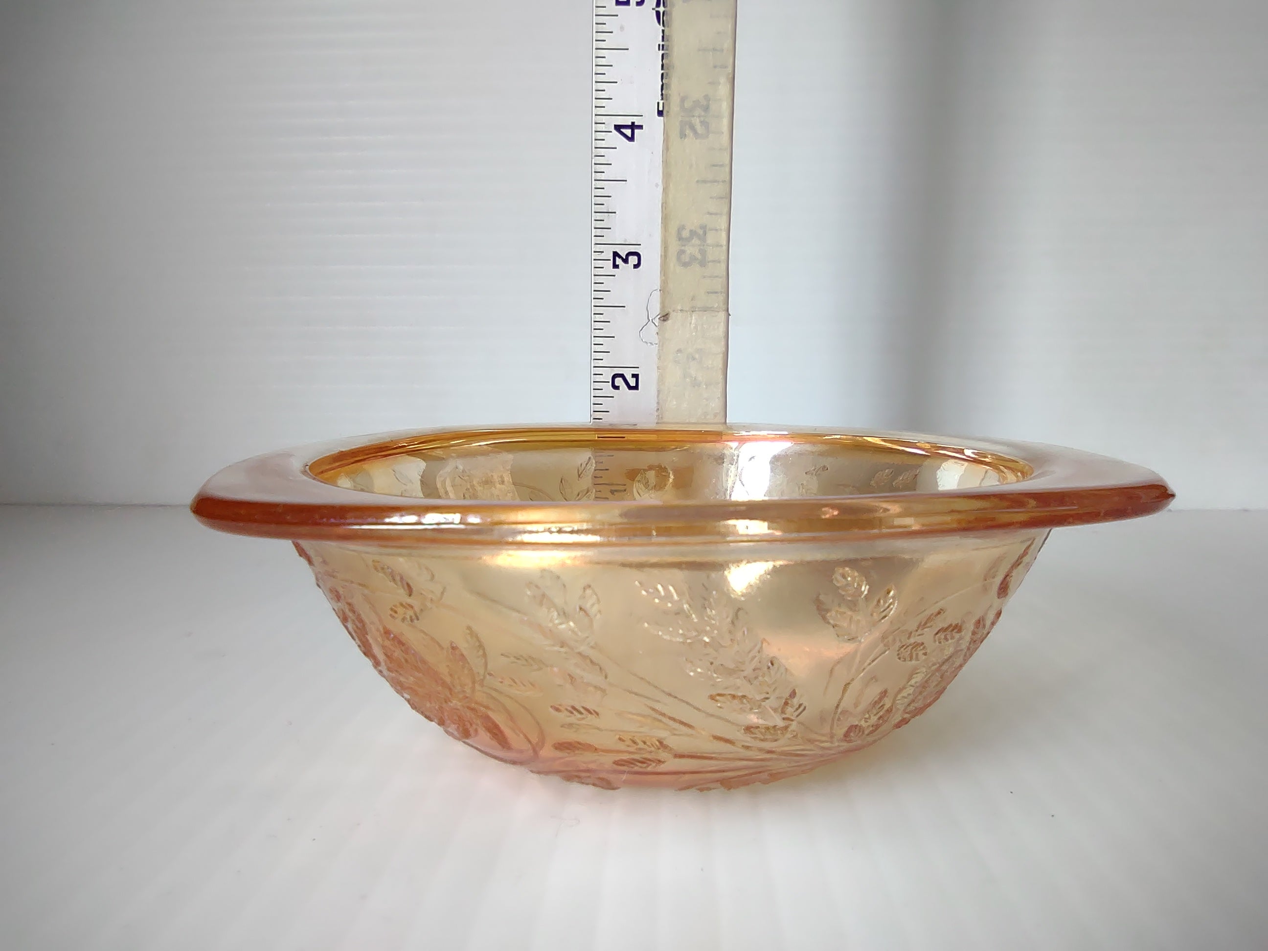 Side view of marigold carnival glass square bowl with ruler showing approximately 3 inches tall