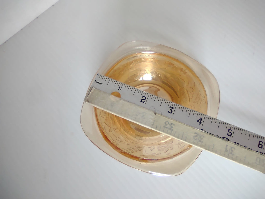 Bottom view of marigold carnival glass square bowl with ruler showing approximately 8 inches wide