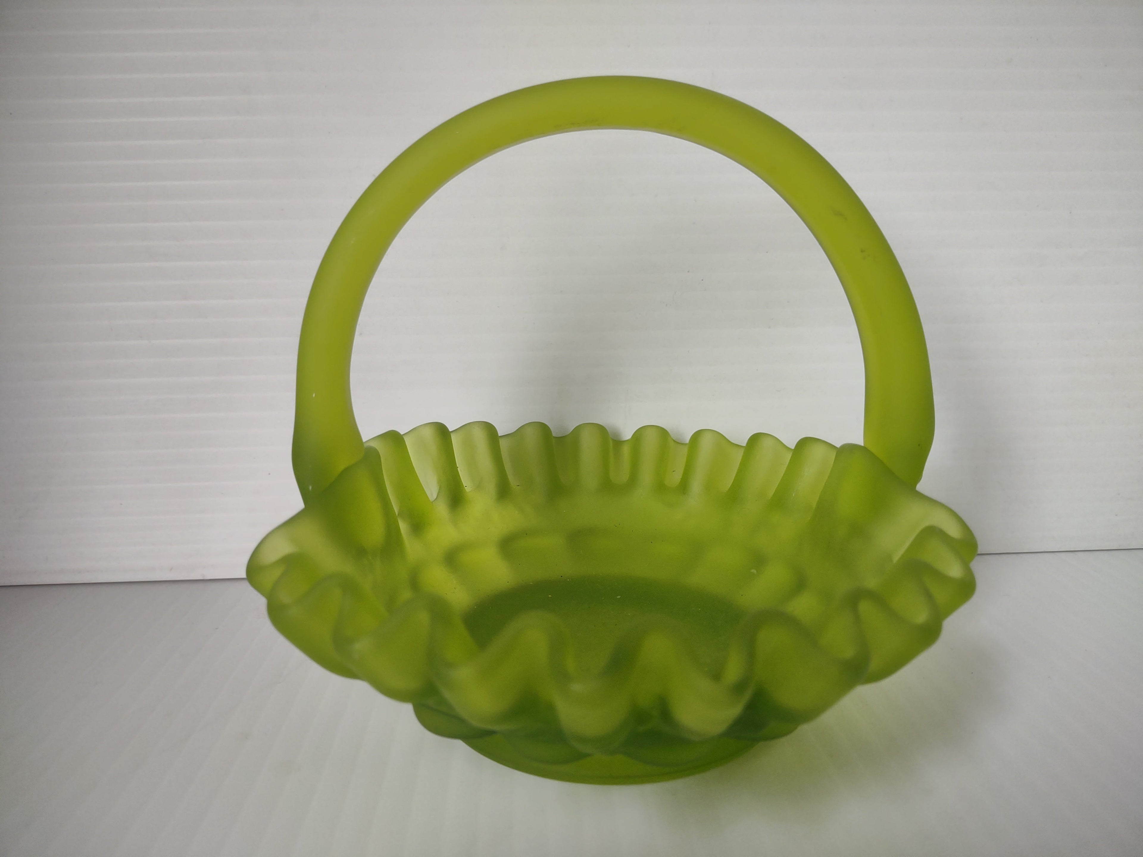 Side view of lime green satin glass hobnail basket with ruler showing approximately 6 inches tall