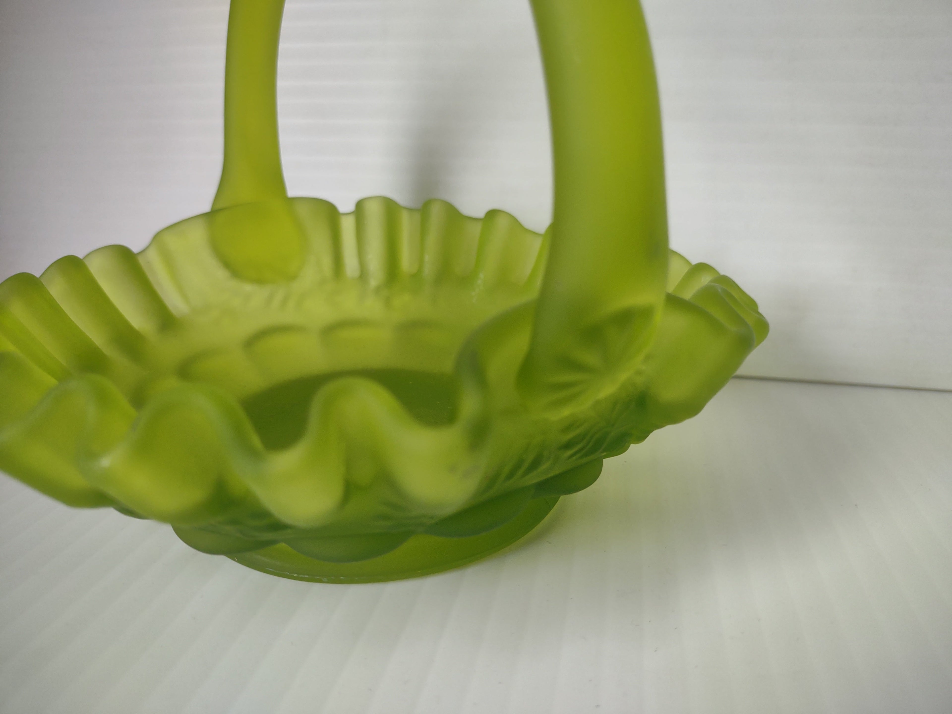 Angled view of lime green satin glass hobnail ruffled basket showing interior