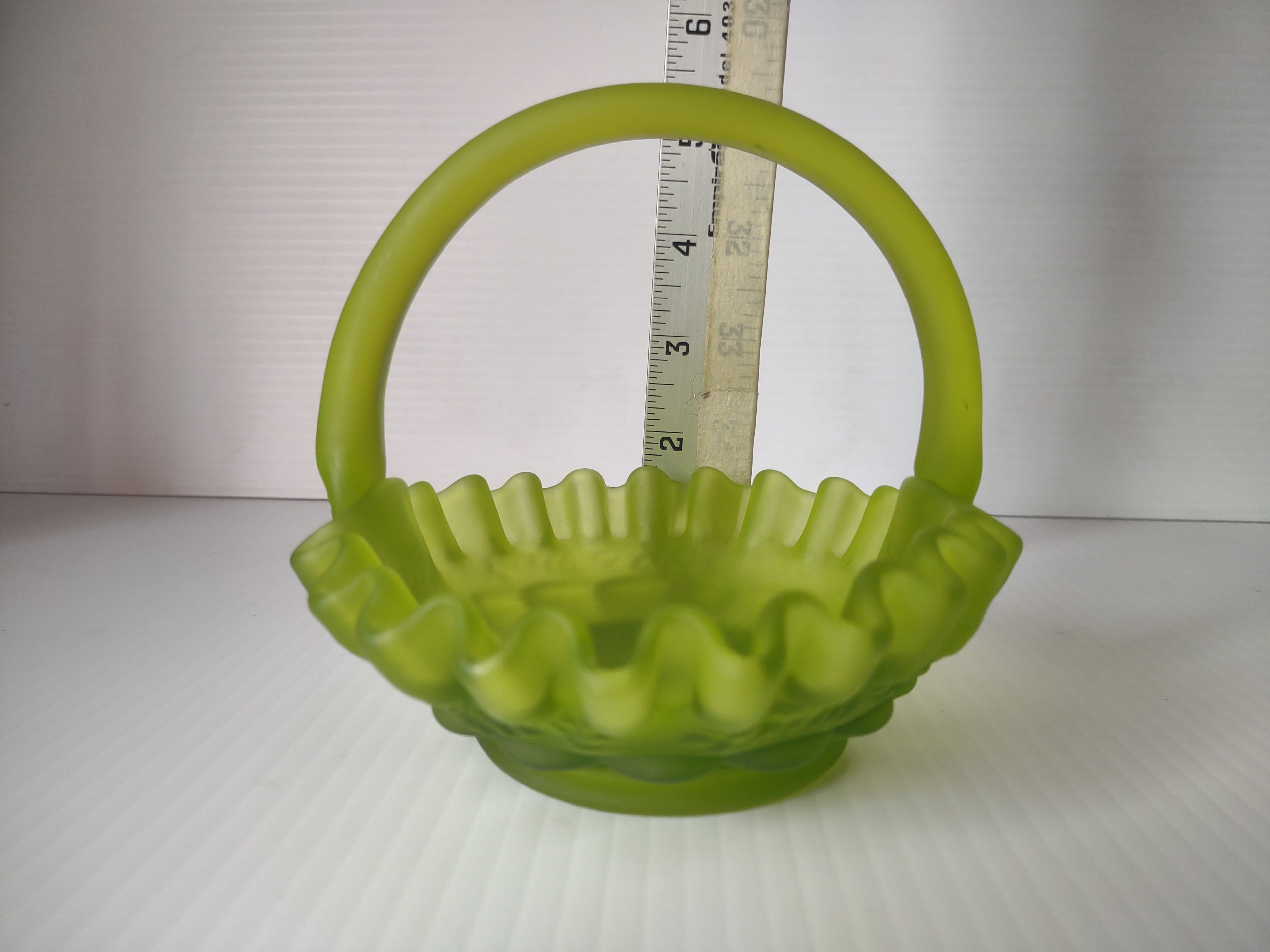 Top-down view of lime green satin glass hobnail basket showing ruffled rim detail