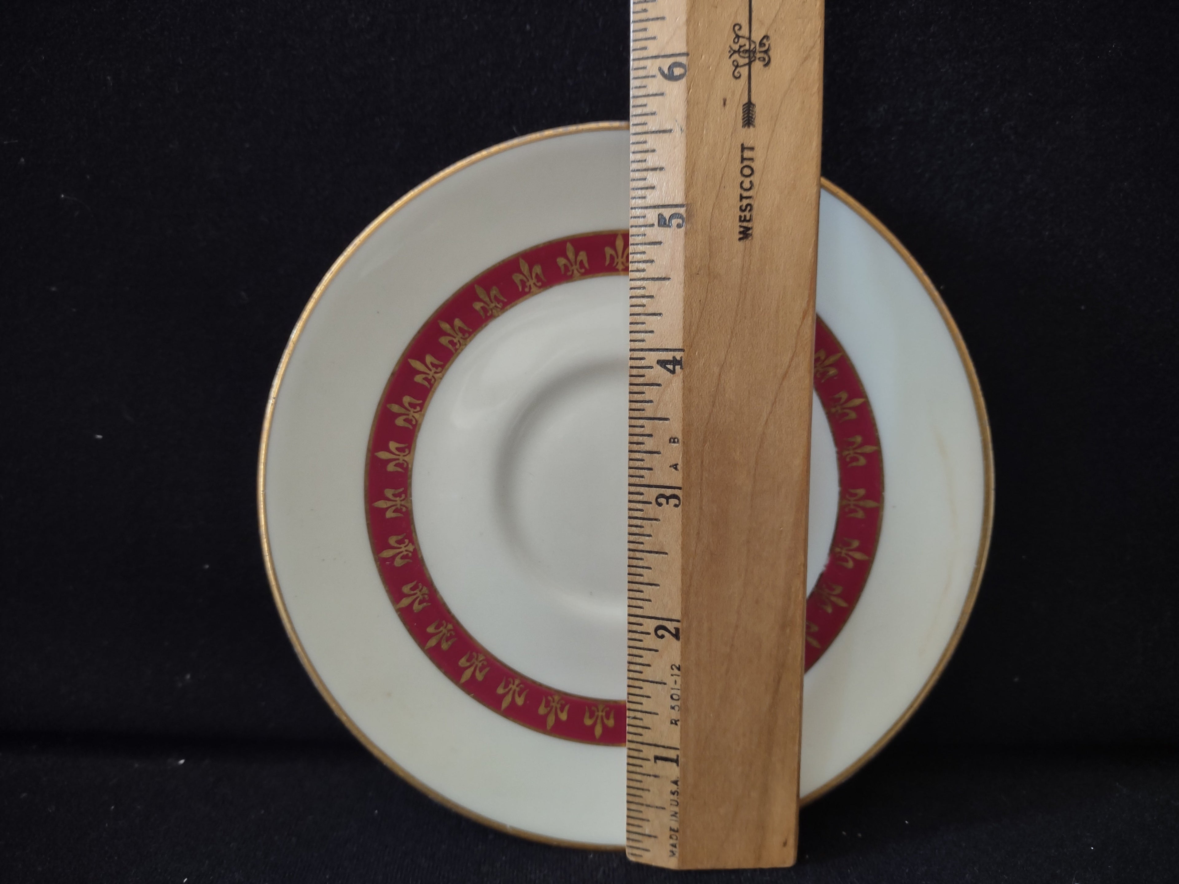 Vintage Theodore Haviland New York red fleur-de-lis saucer with ruler showing approximately 6 inch diameter