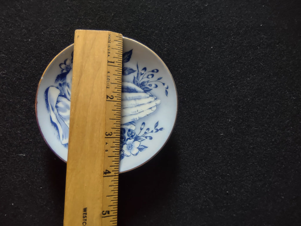 Vintage blue white praying hands plate close-up upper praying hands detail