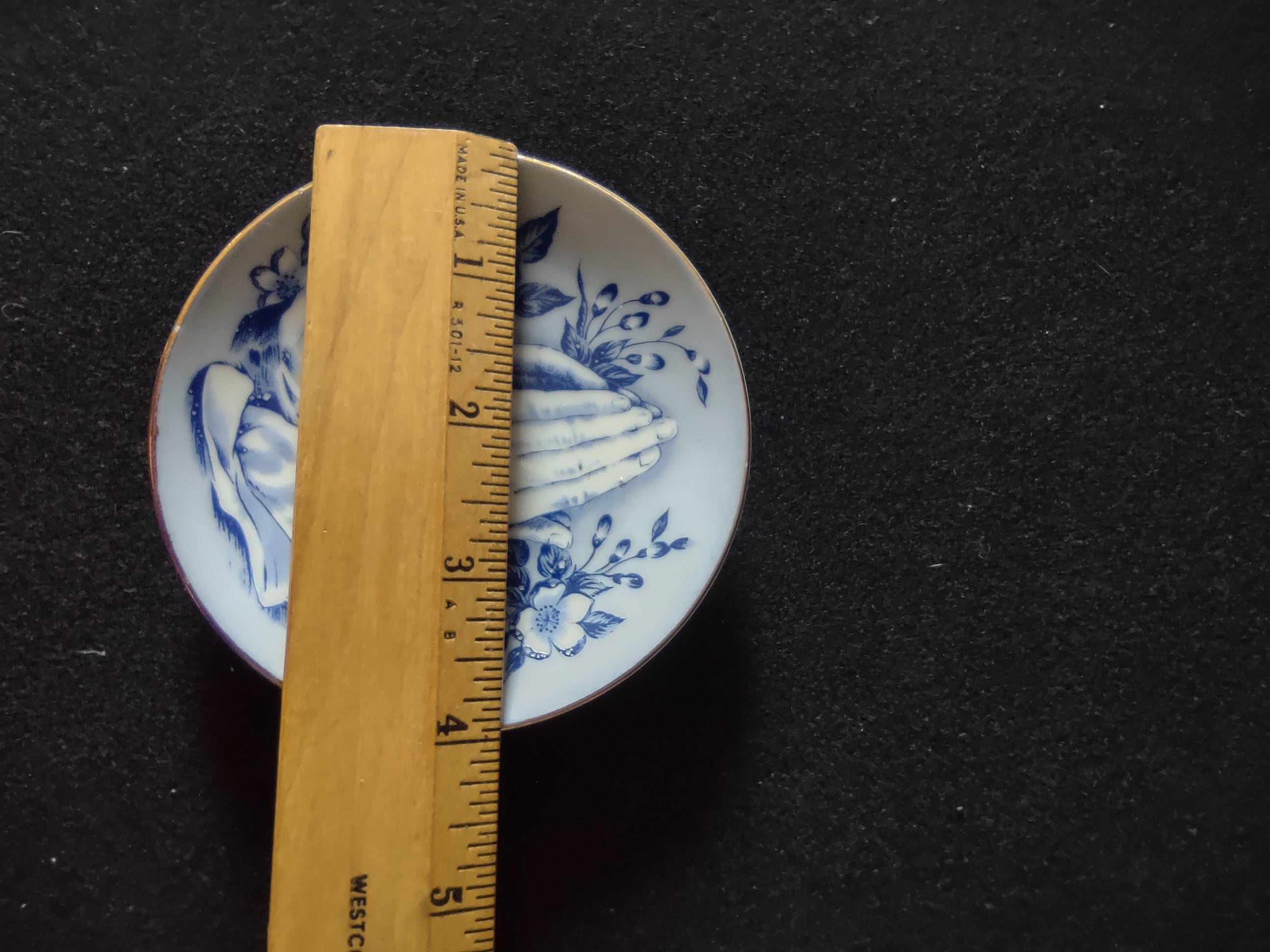 Vintage blue white praying hands plate close-up upper praying hands detail